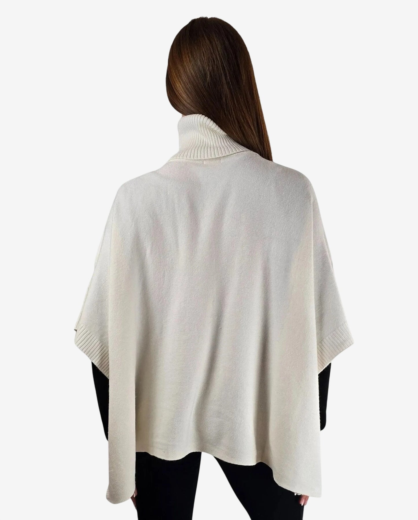 Poncho color crema con collo alto a costine indossato da una donna di spalle.
