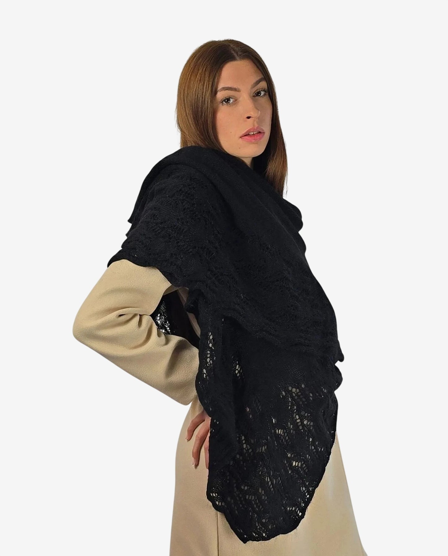 A woman wears a black mohair shawl with a delicate lace pattern over a beige coat.