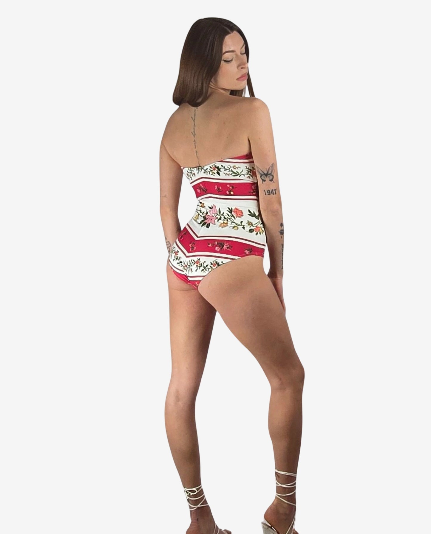 Costume intero a fascia con righe orizzontali rosse e bianche e stampa floreale.