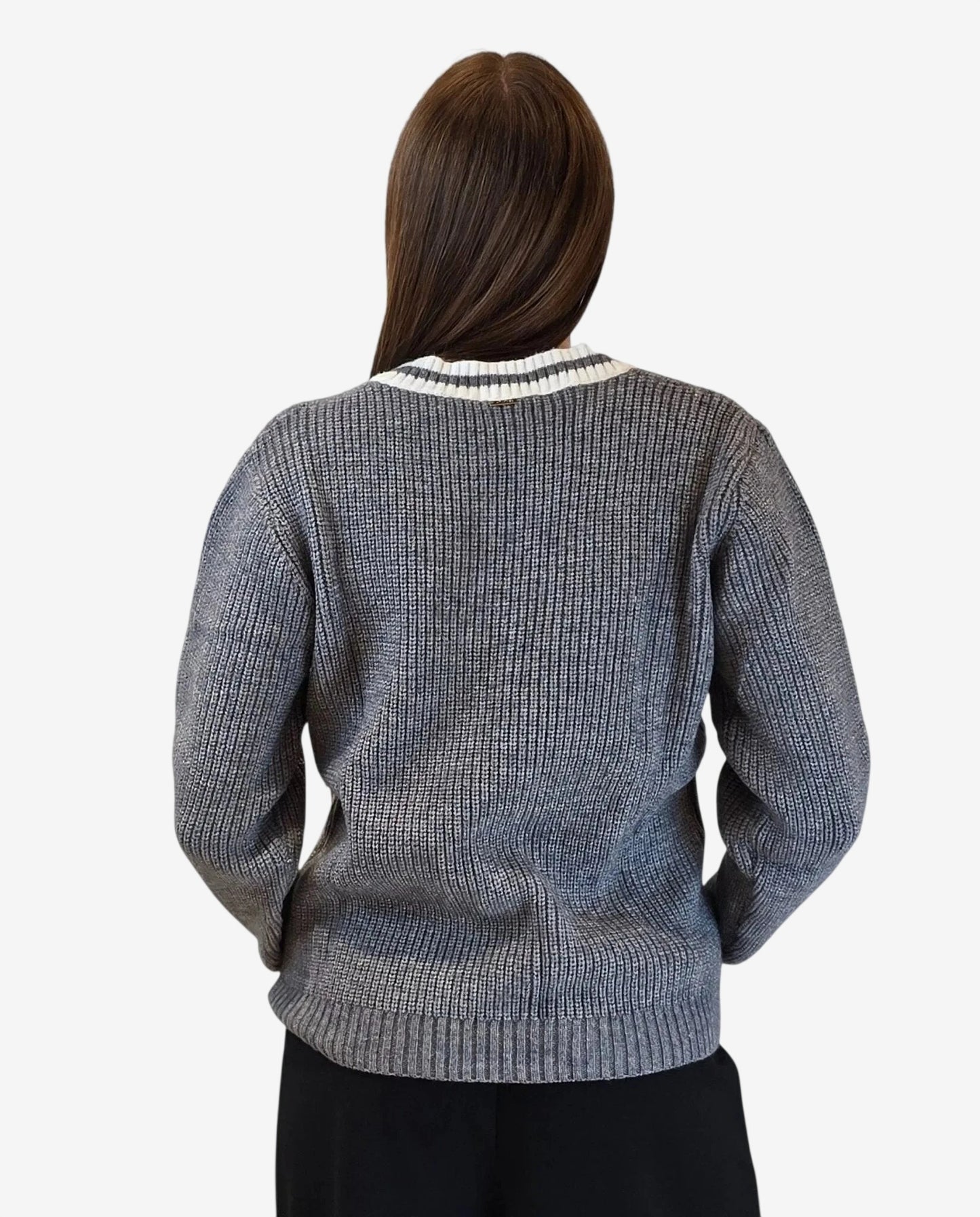 A person seen from behind wearing a grey ribbed knit pullover with a striped collar.