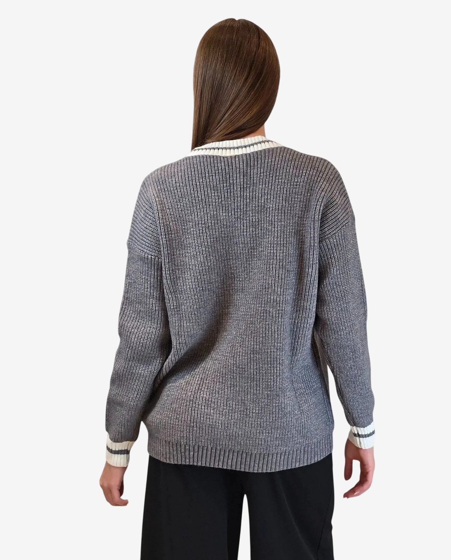 Cardigan grigio a maglia con bordi a righe bianche e scure visto di spalle.