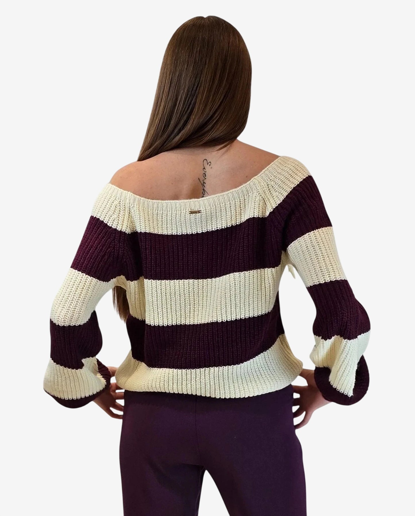 A woman wears a cream and burgundy striped off-the-shoulder knit pullover.
