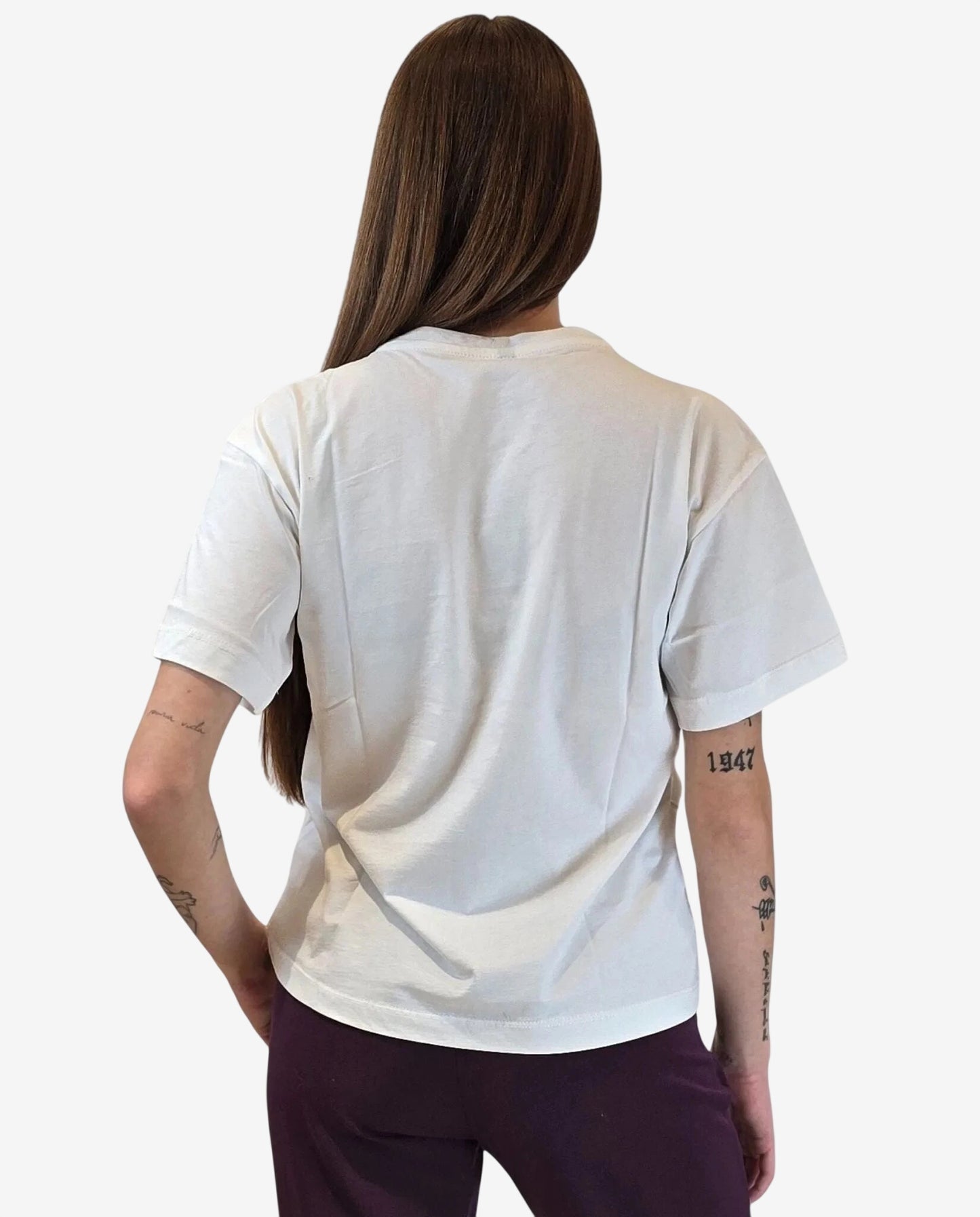 Una persona indossa una t-shirt bianca a maniche corte vista di spalle.