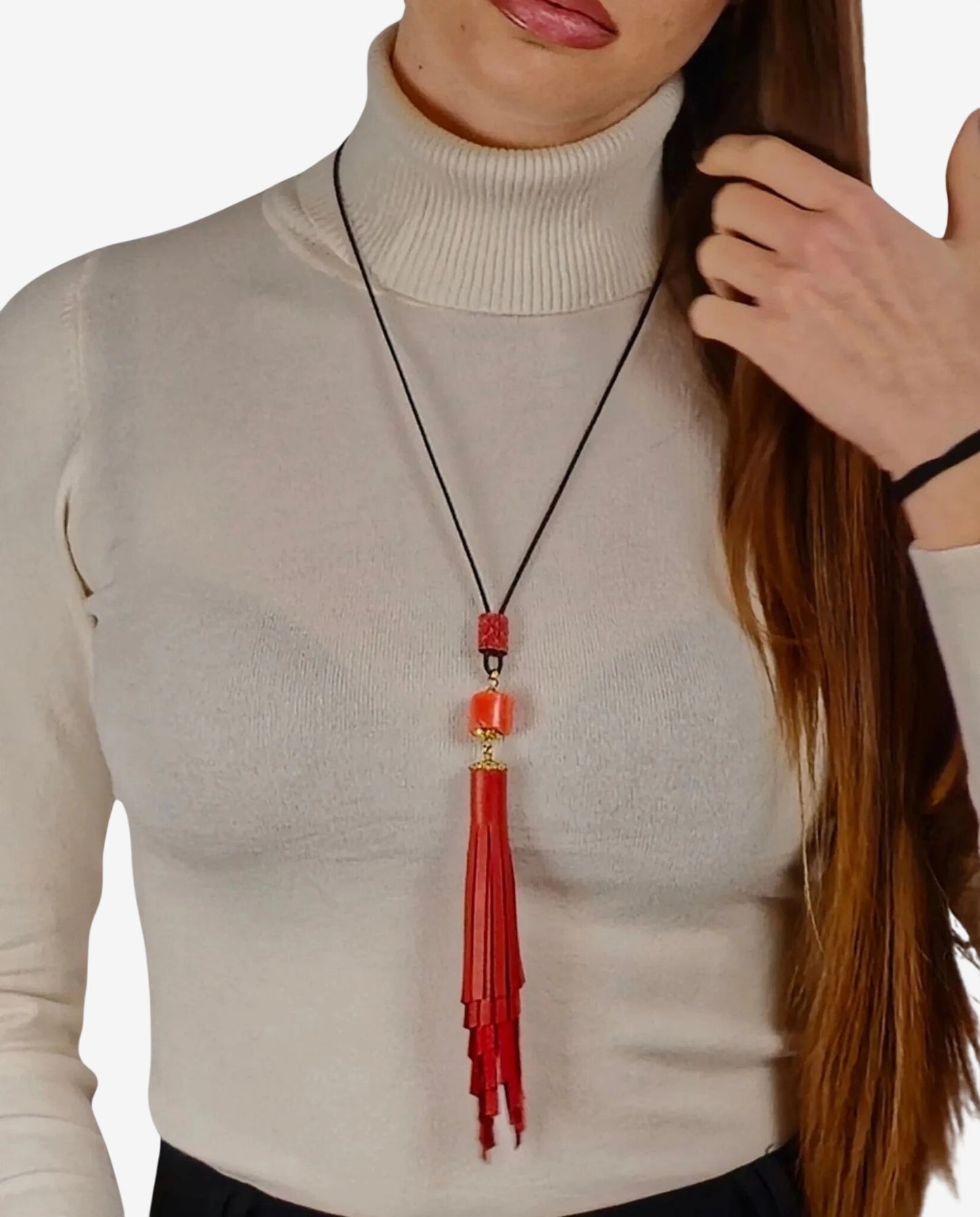 Collana artigianale con nappa in vera pelle color corallo e inserto in corallo tubolare.
