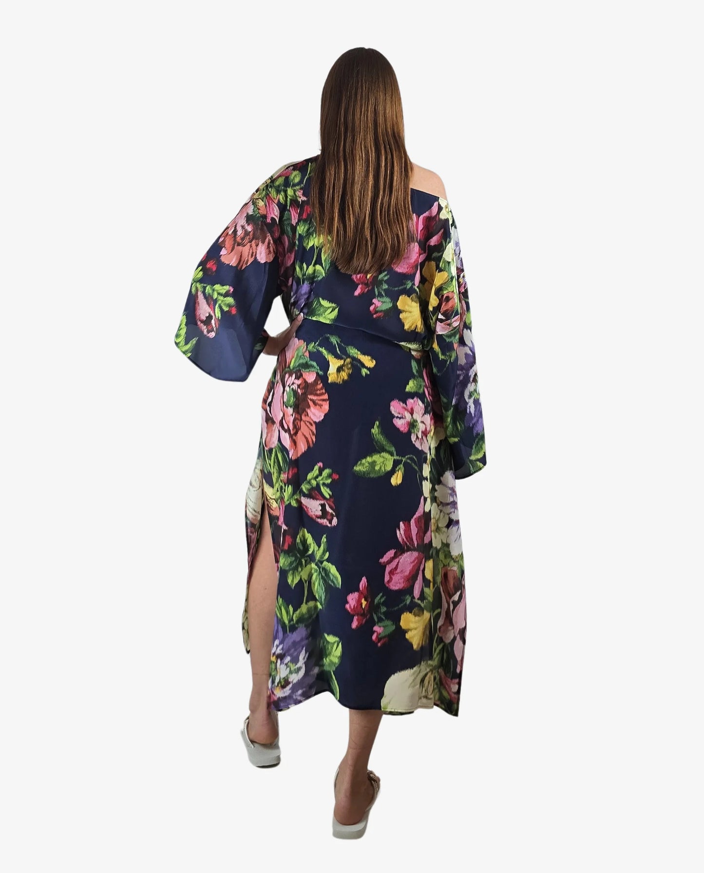 Poncho lungo con fantasia floreale multicolor su fondo blu e maniche ampie a kimono.