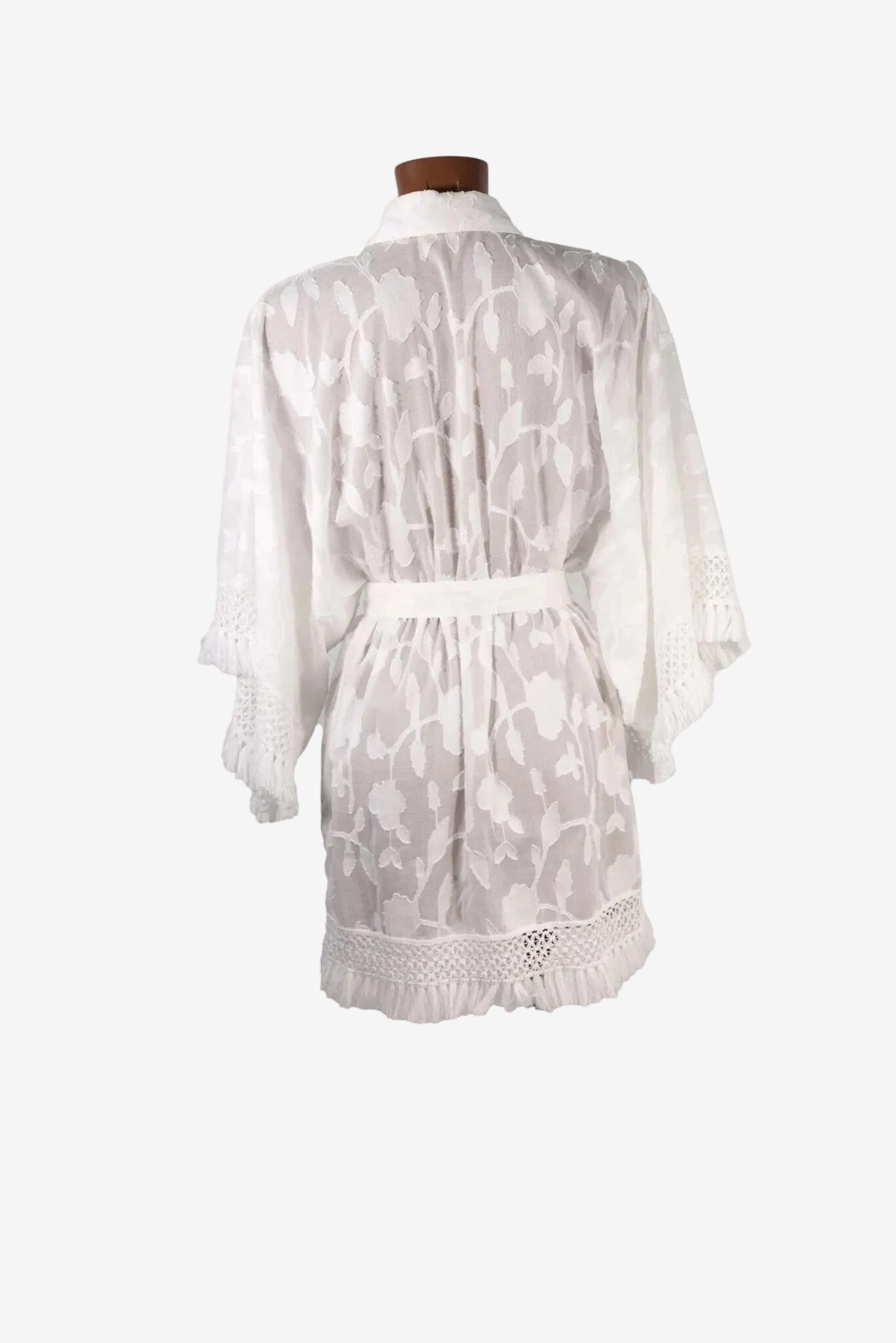 Kimono corto bianco in tessuto fil coupé con maniche ampie, rifinito con greca e nappine.