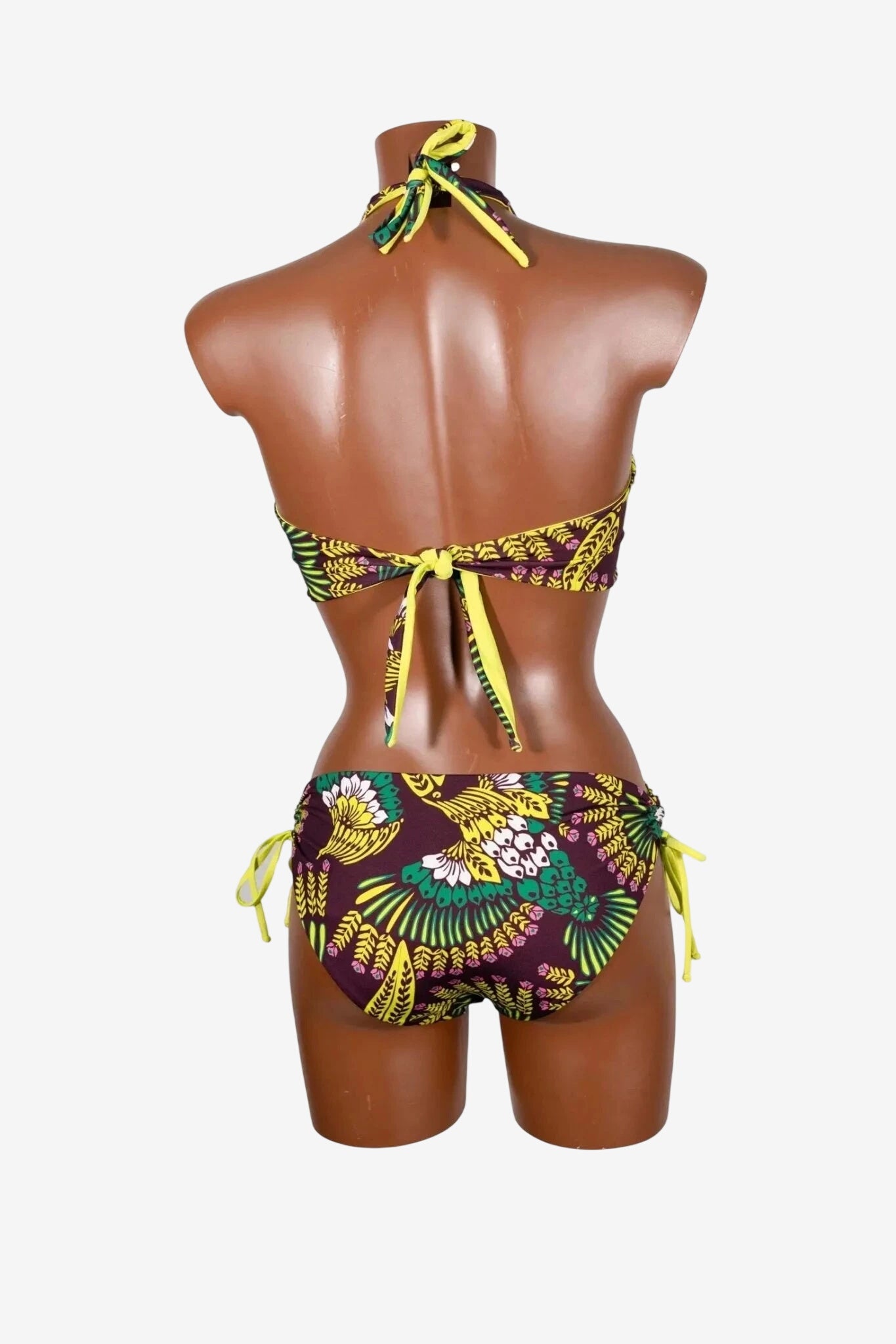 Bikini triangolare con stampa tropicale nei toni del giallo, verde e viola su manichino.