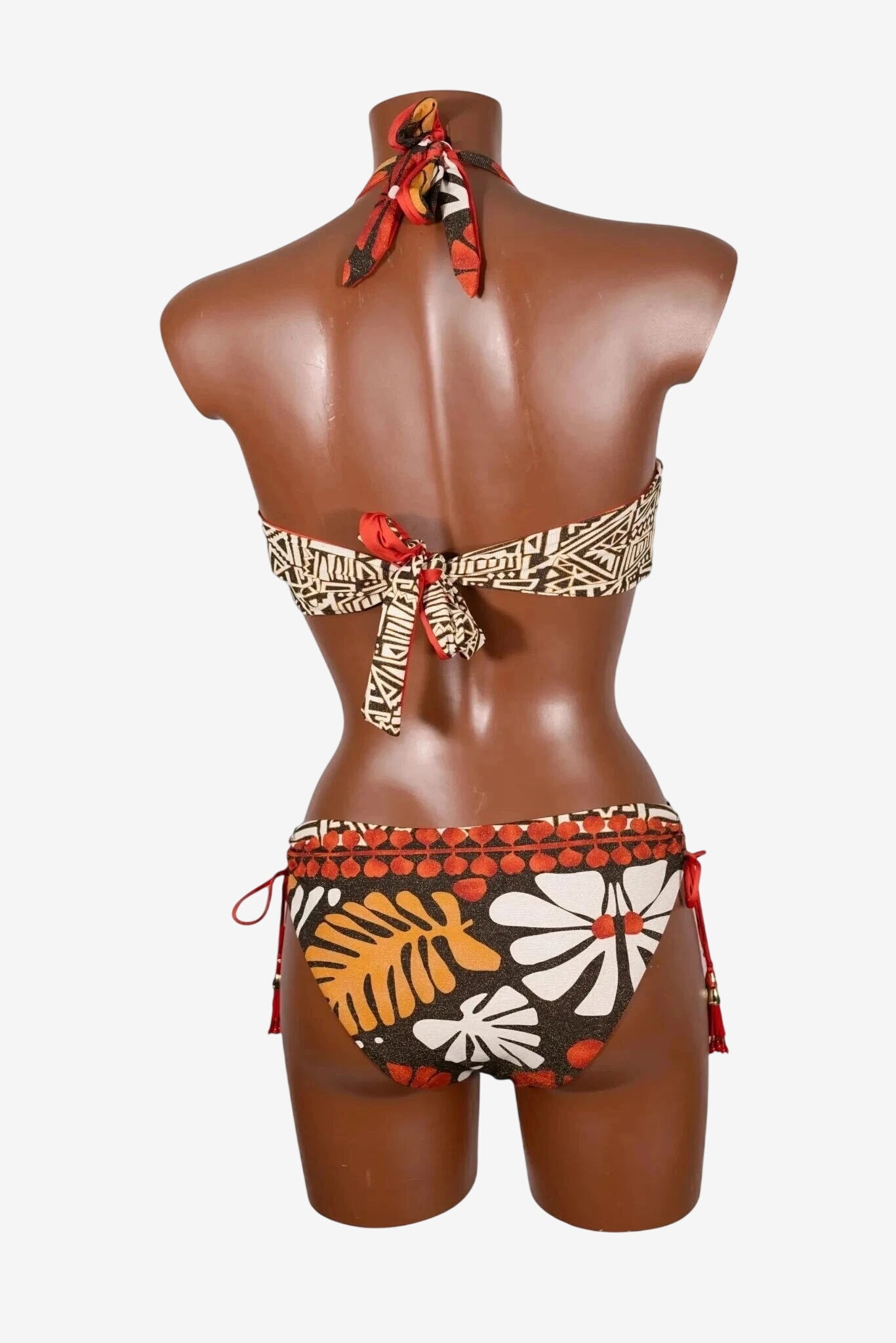 A back view of a brown and orange patterned bikini set with tie closures on a mannequin.