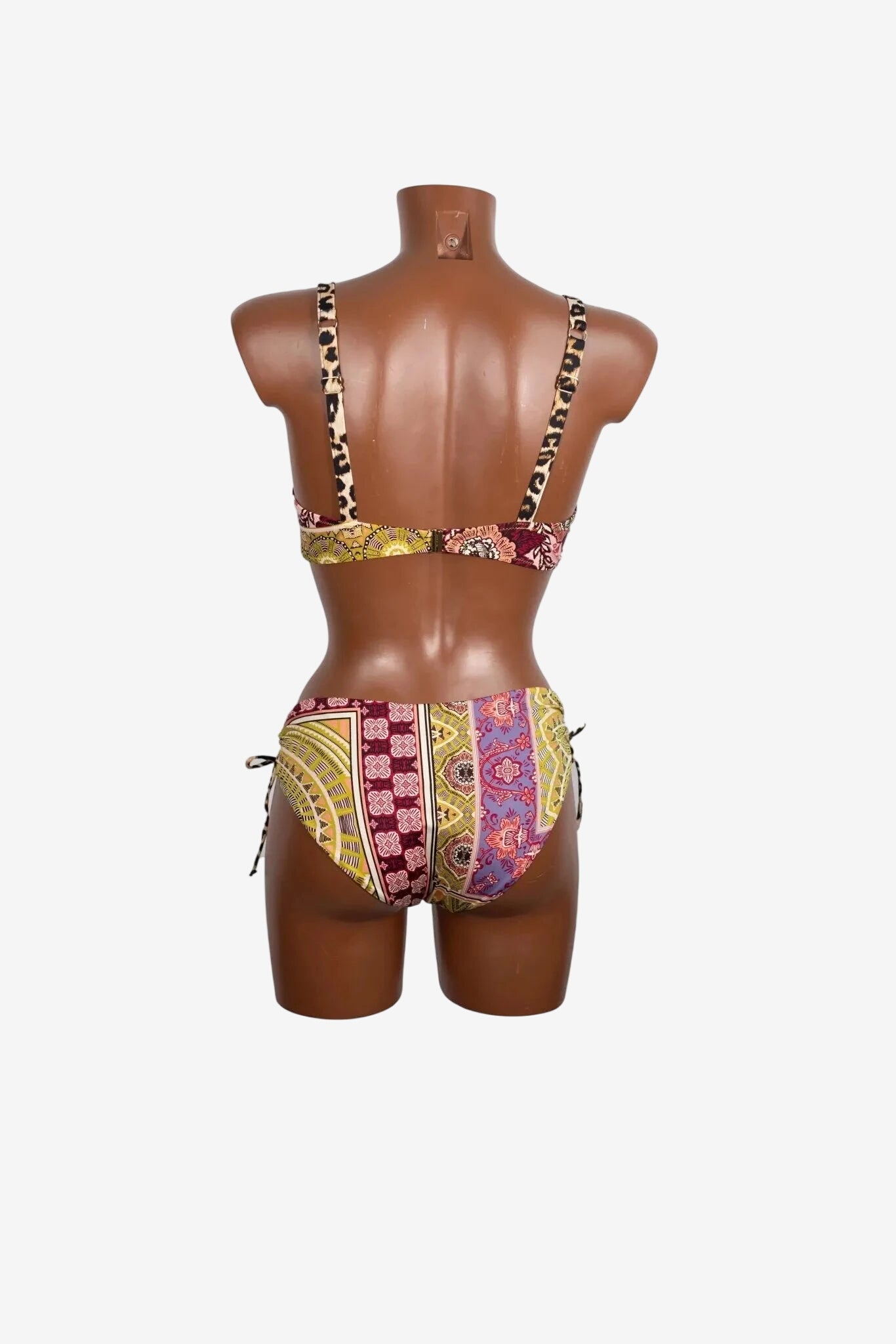 A back view of a patterned bikini set with leopard print straps on a mannequin.