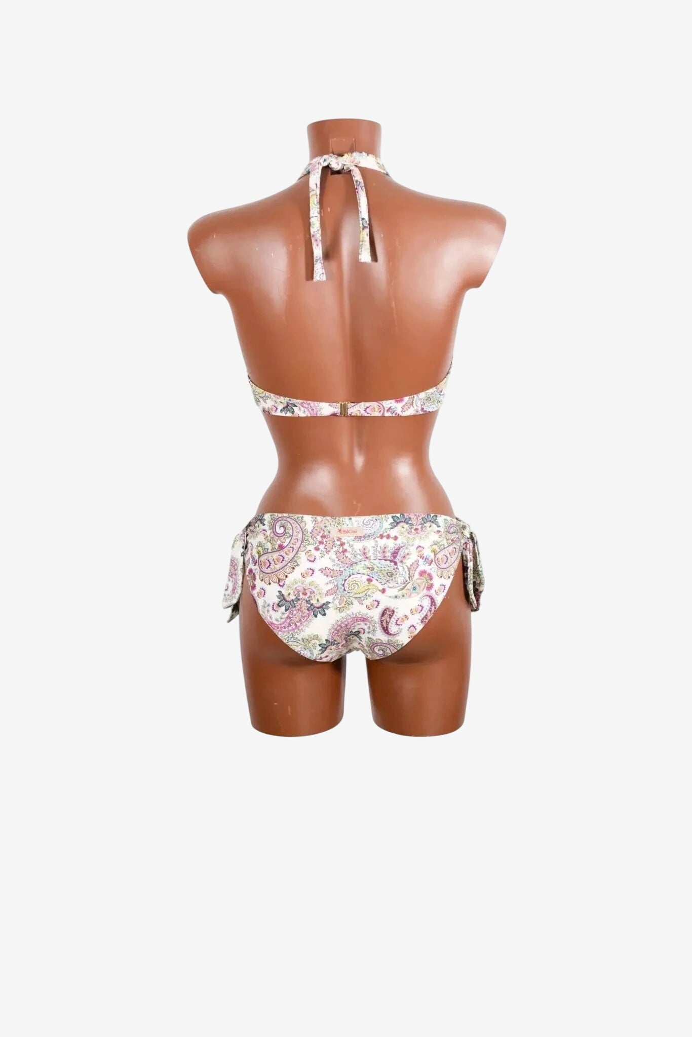 A back view of a paisley print bikini with a halter top and side-tie bottoms on a mannequin.