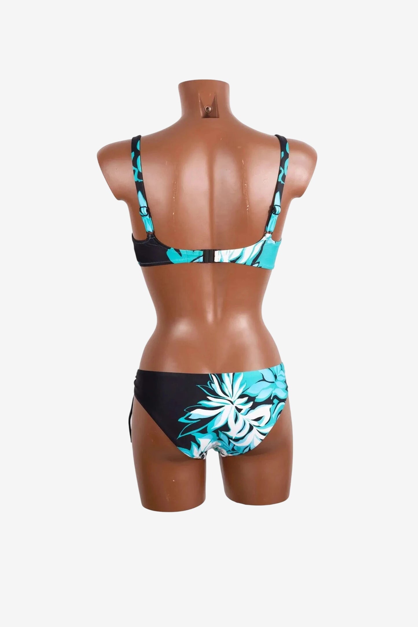 A back view of a black bikini set featuring a teal and white floral print on the bottoms and straps.