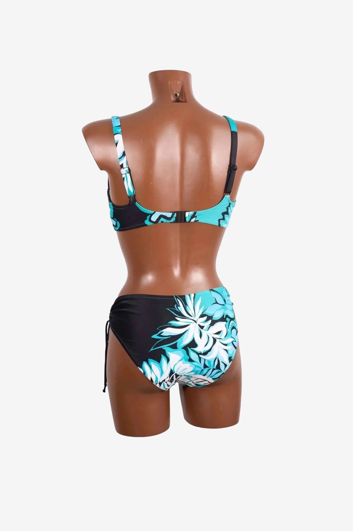A back view of a black and teal floral print bikini set with adjustable straps on a mannequin.