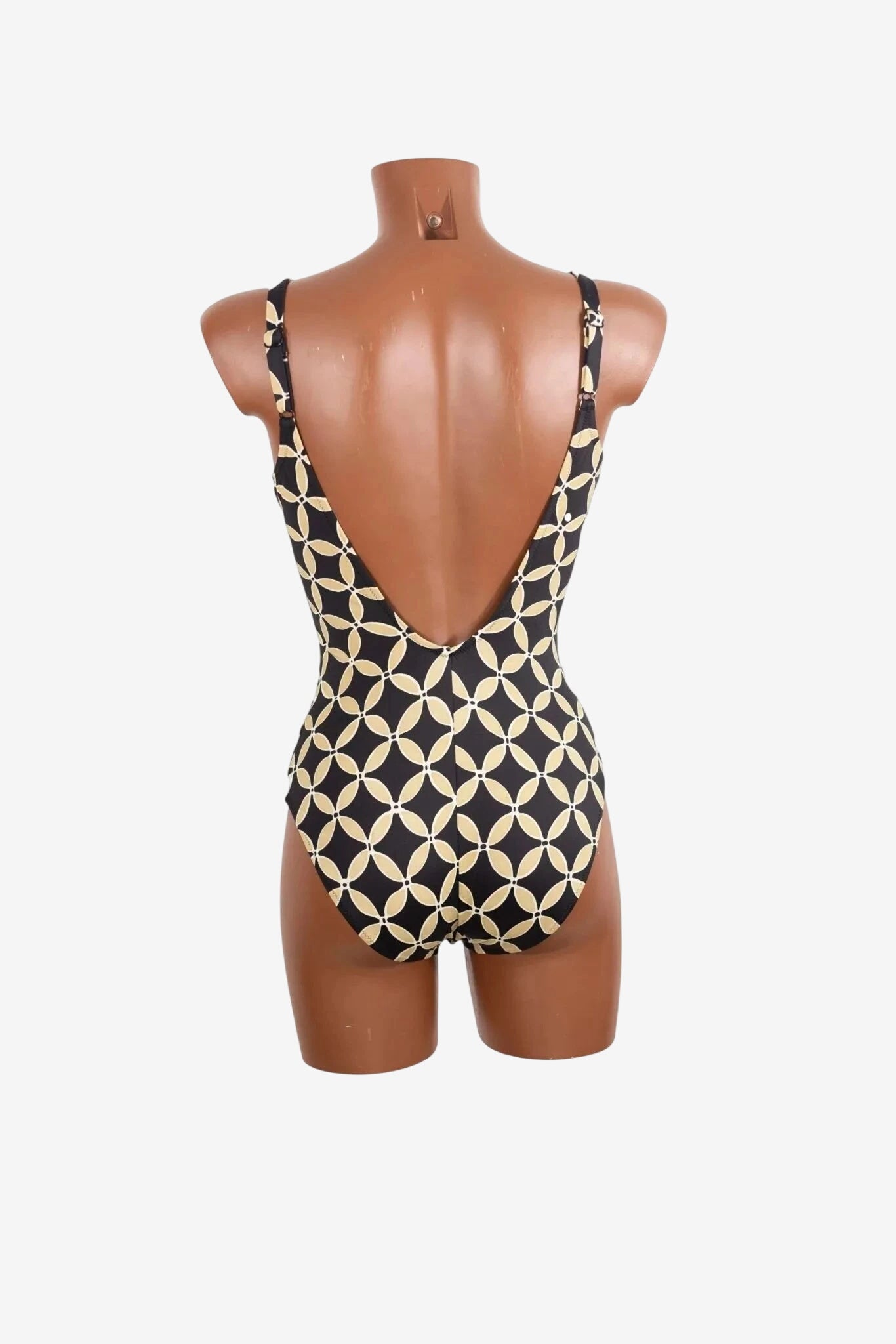 Costume intero Roidal con scollo profondo e fantasia geometrica beige su fondo nero.