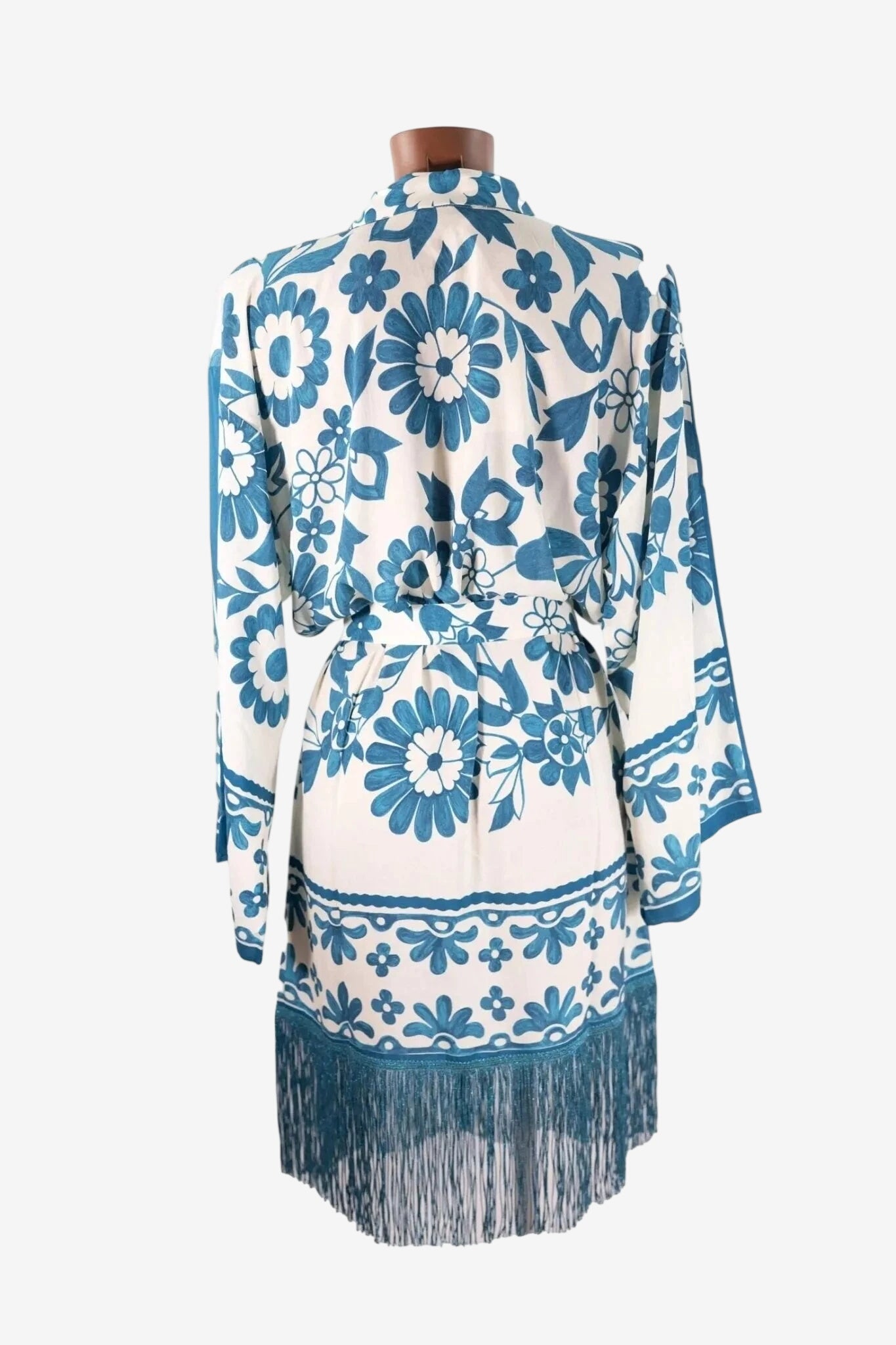 Kimono copricostume bianco con stampa floreale blu e frange lurex sul fondo.