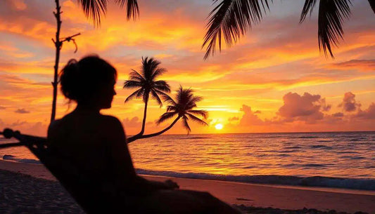 Tramonto tropicale sulla spiaggia con palme, donna rilassata su amaca, Soho Moda Mare