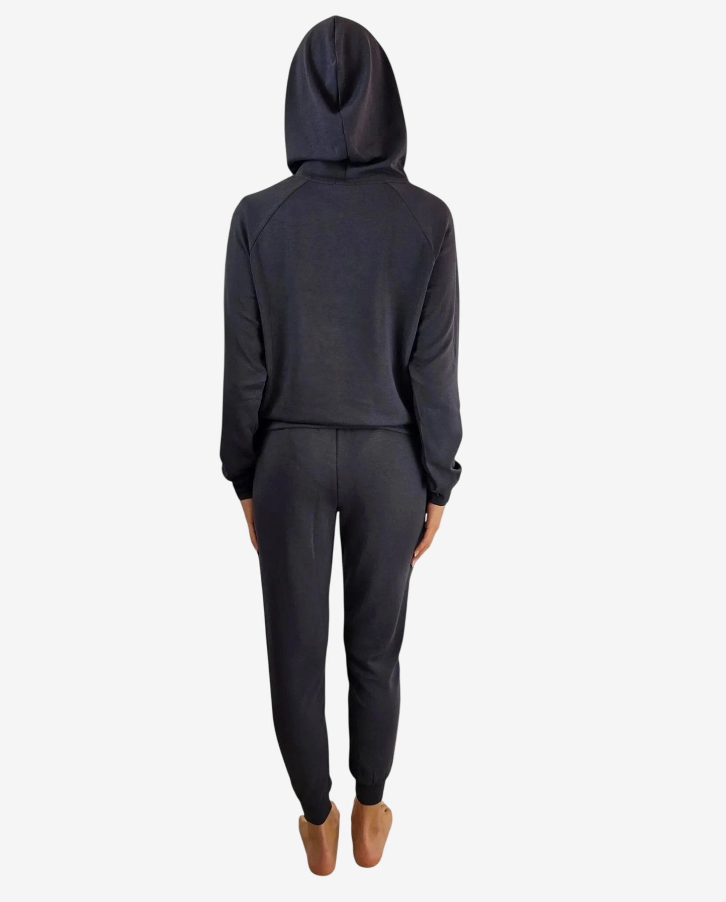 Vista posteriore di una tuta sportiva nera con cappuccio indossata da una donna.