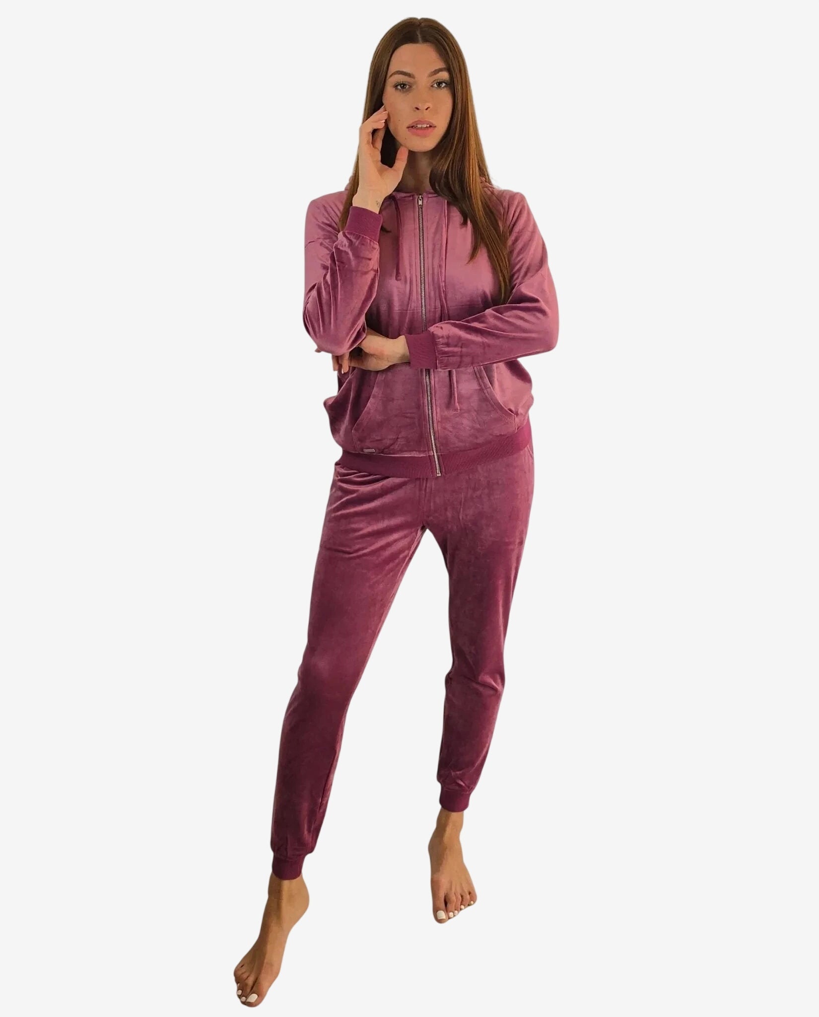 Una donna indossa una tuta in ciniglia color malva composta da felpa con cappuccio e pantaloni.