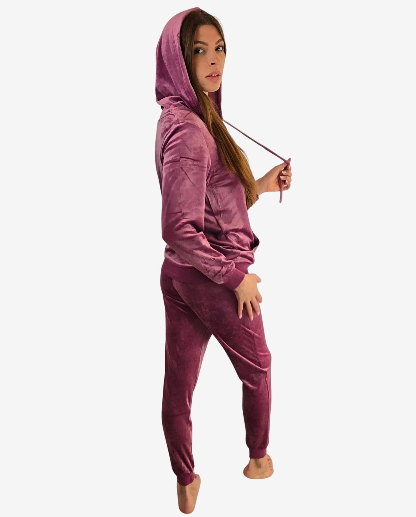 Una donna indossa una tuta in ciniglia color prugna composta da felpa con cappuccio e pantaloni.