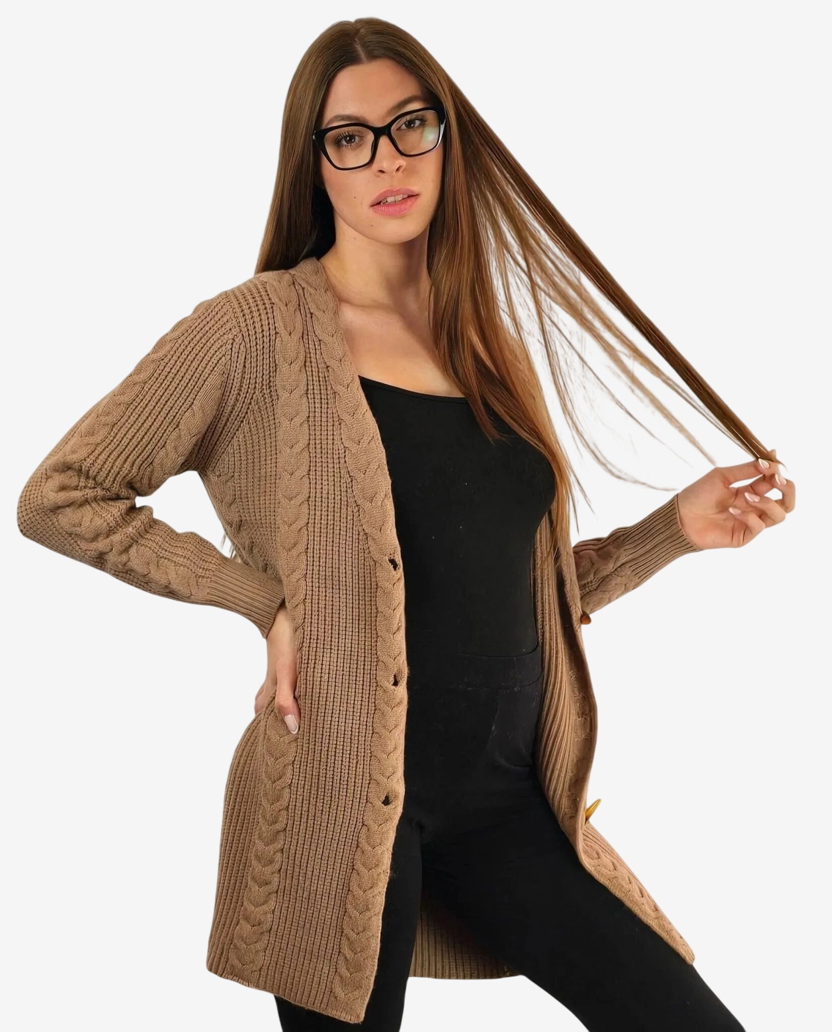 Modella indossa un cardigan color cammello lavorato a treccia sopra un completo nero.