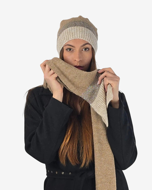 Modella indossa un set coordinato di sciarpa e cappello in lana beige con dettagli in lurex.