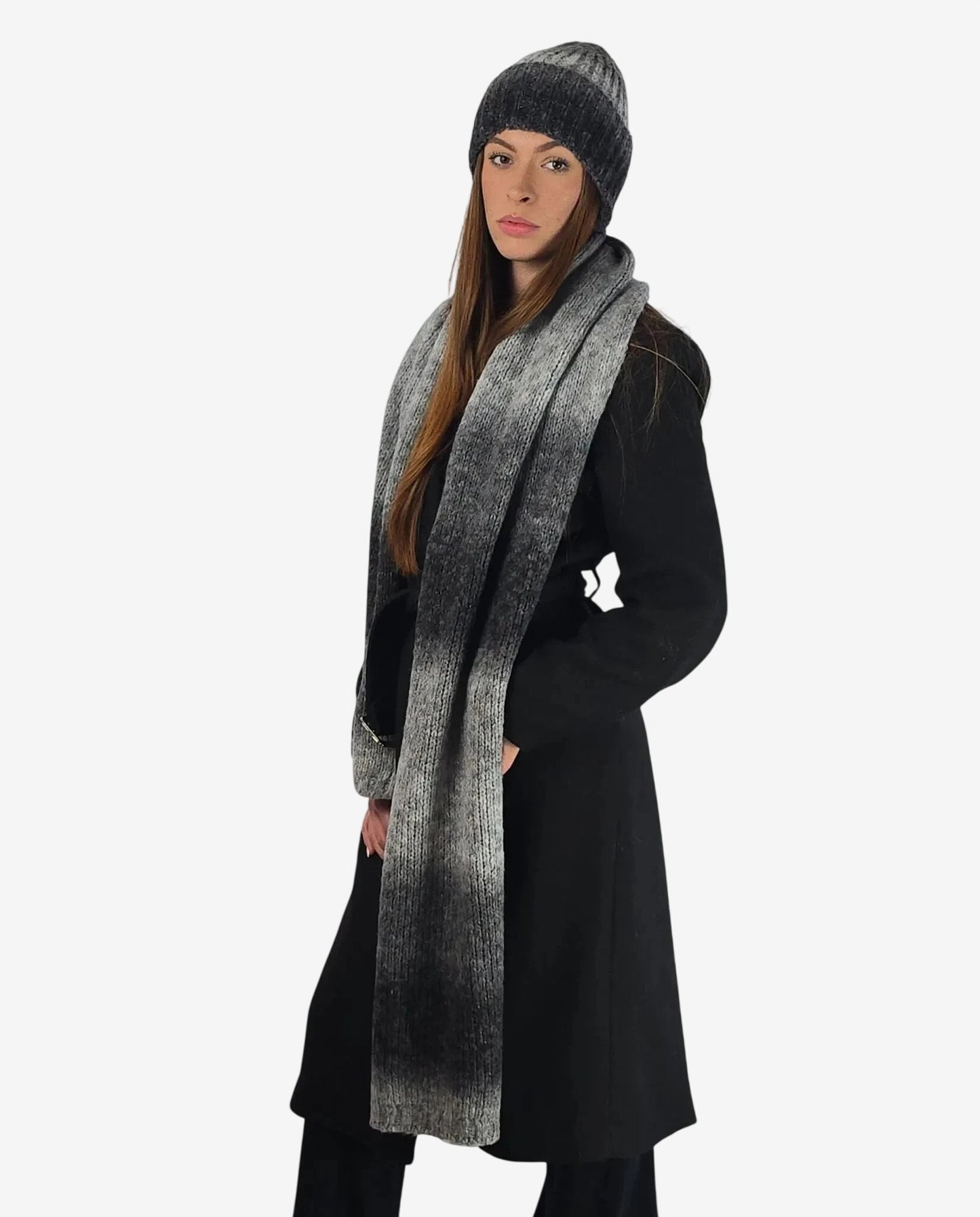 Modella indossa un set coordinato di sciarpa e cuffia in lana con sfumatura grigia.