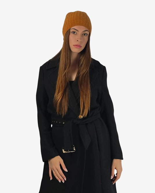 Modella che indossa una cuffia in cachemire color terracotta con lavorazione a maglia.