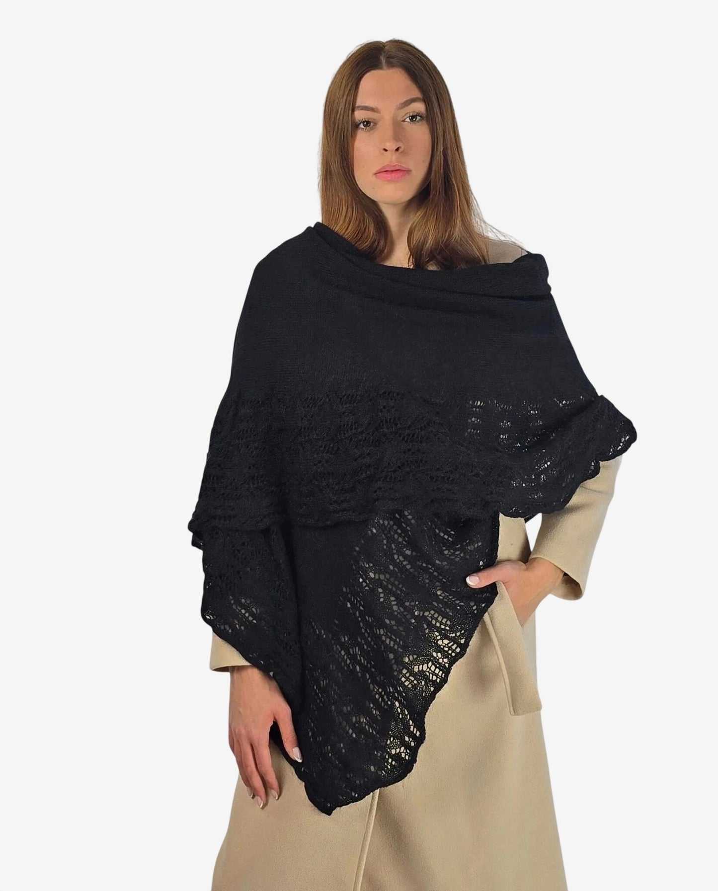 A woman wears a black mohair shawl featuring a delicate lace pattern over a beige coat.