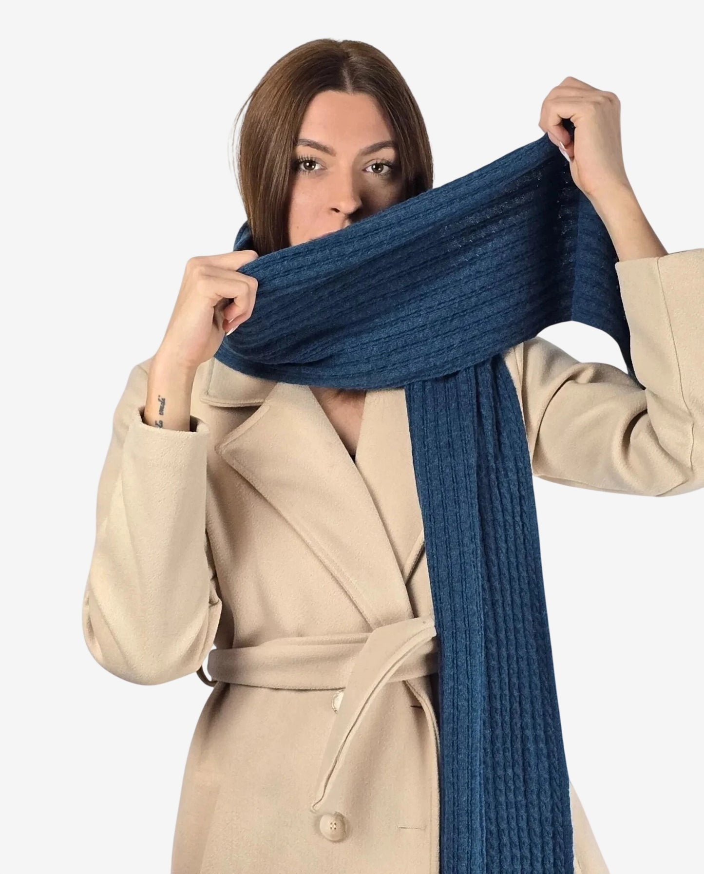 Una donna indossa una sciarpa a coste color ottanio in misto lana e cachemire.