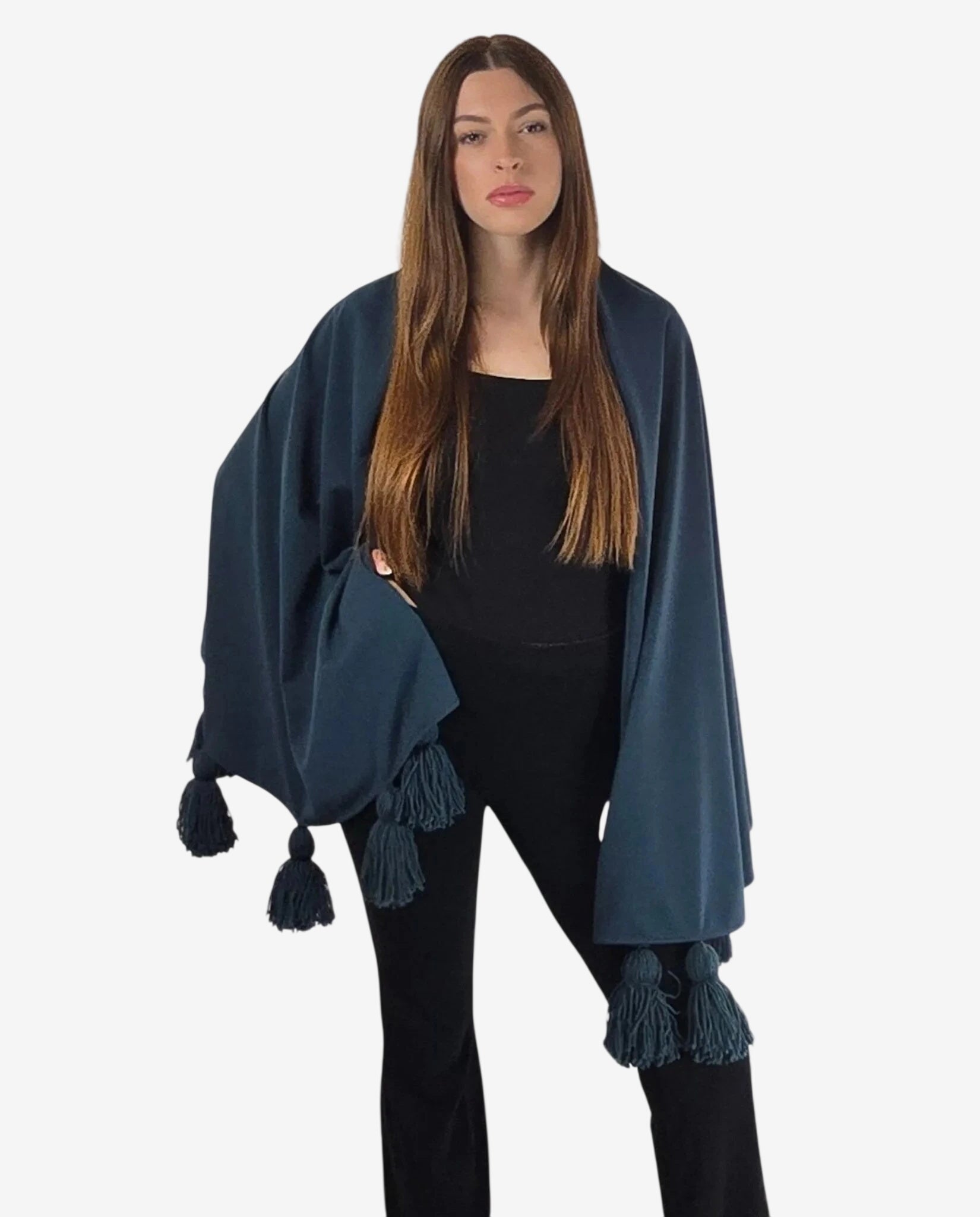 Modella indossa una mantella blu in viscosa con nappe in lana merinos su un completo nero.