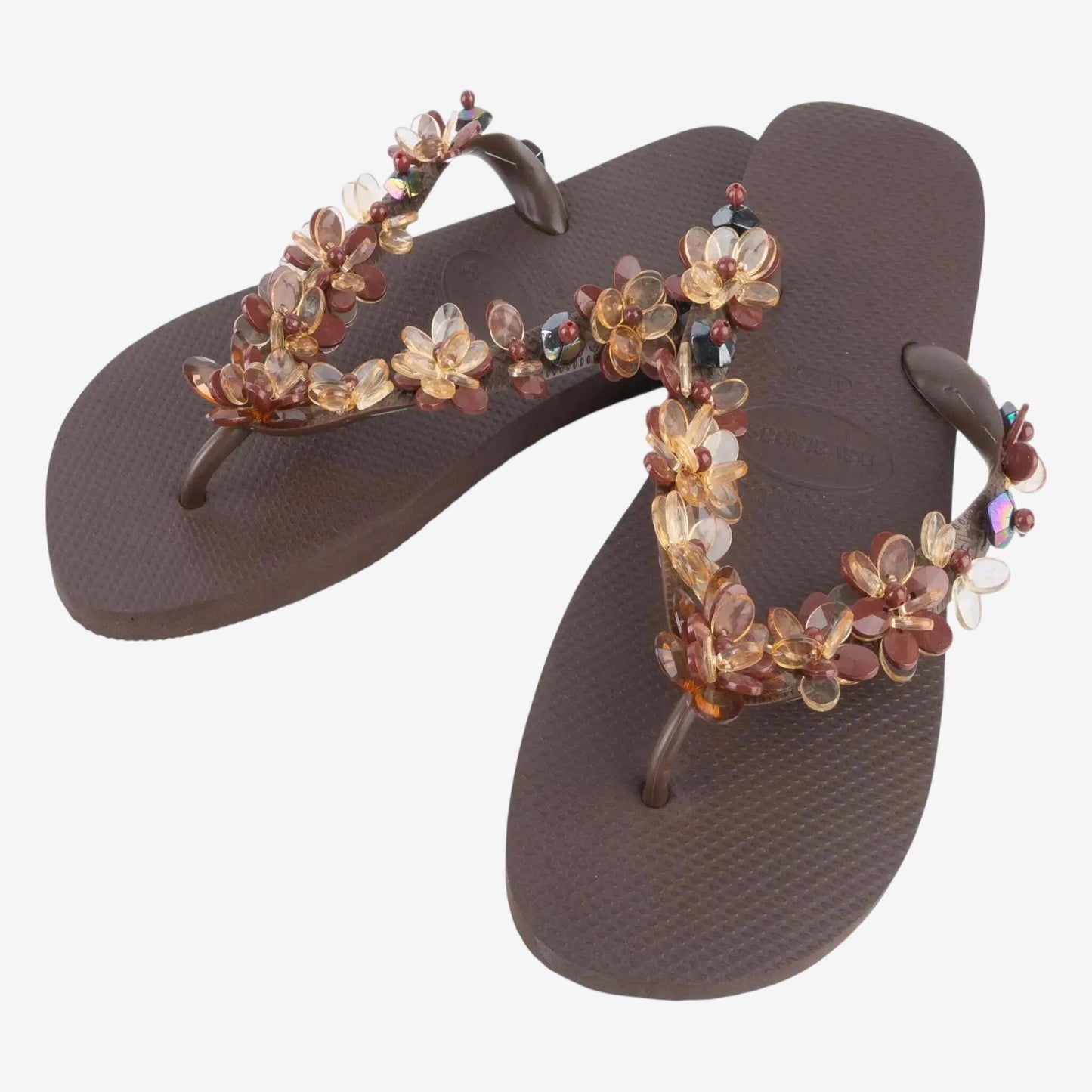 Infradito Havaianas marroni decorate con fiori e pietre preziose applicate a mano.