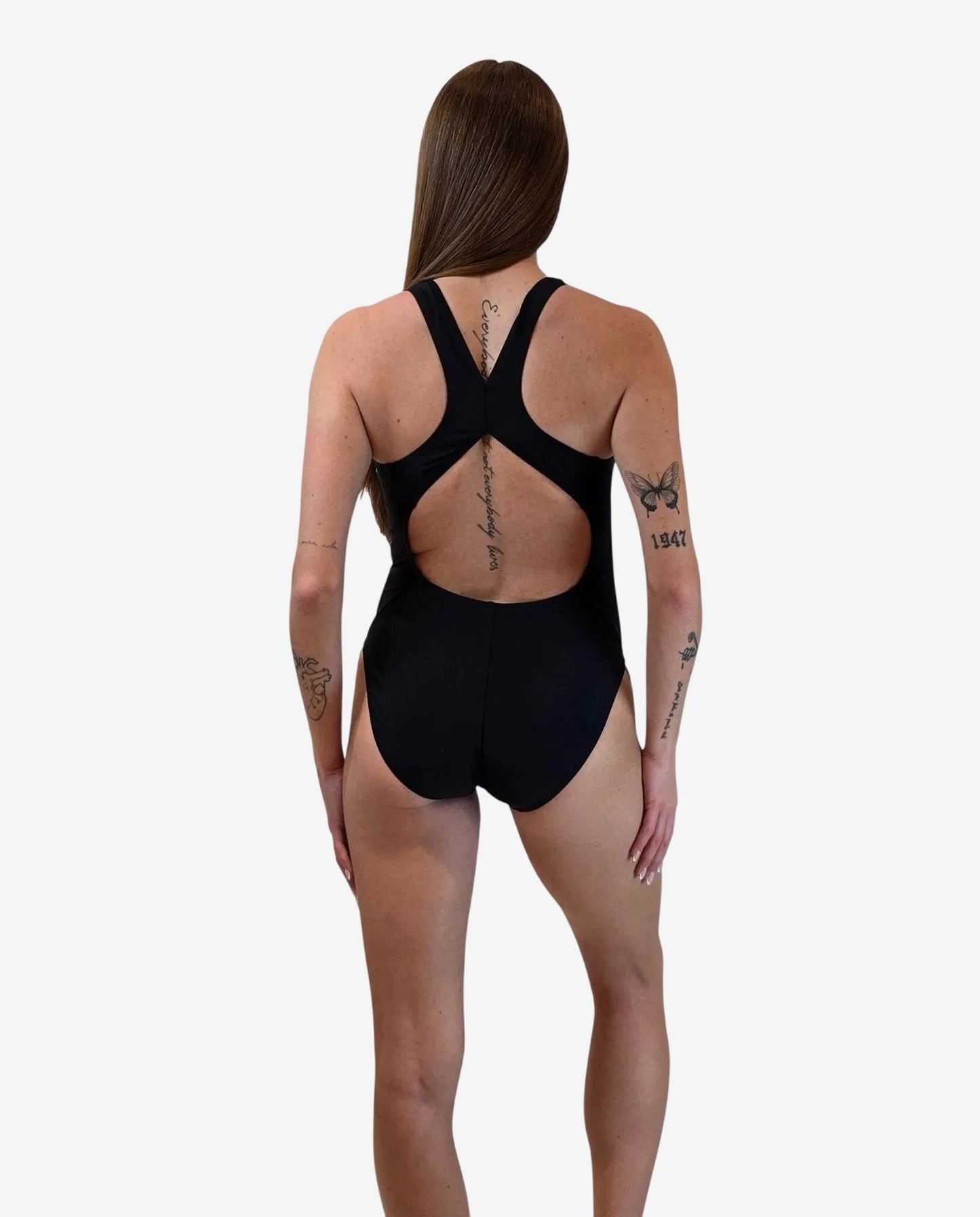 A woman wears a black one-piece swimsuit with a racerback design and a cutout back.
