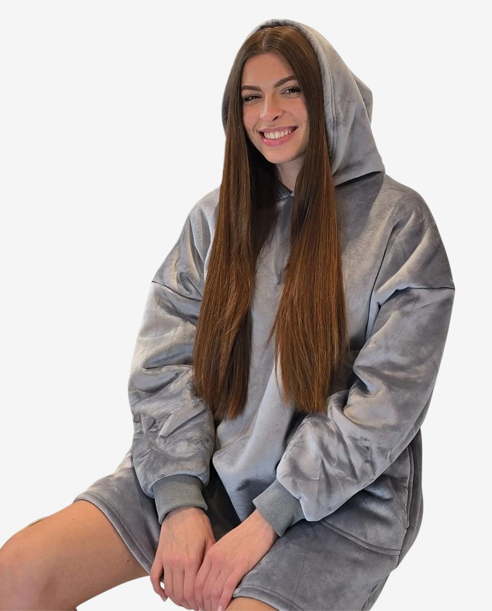 Modella che indossa un abito oversize grigio in morbido tessuto con cappuccio.