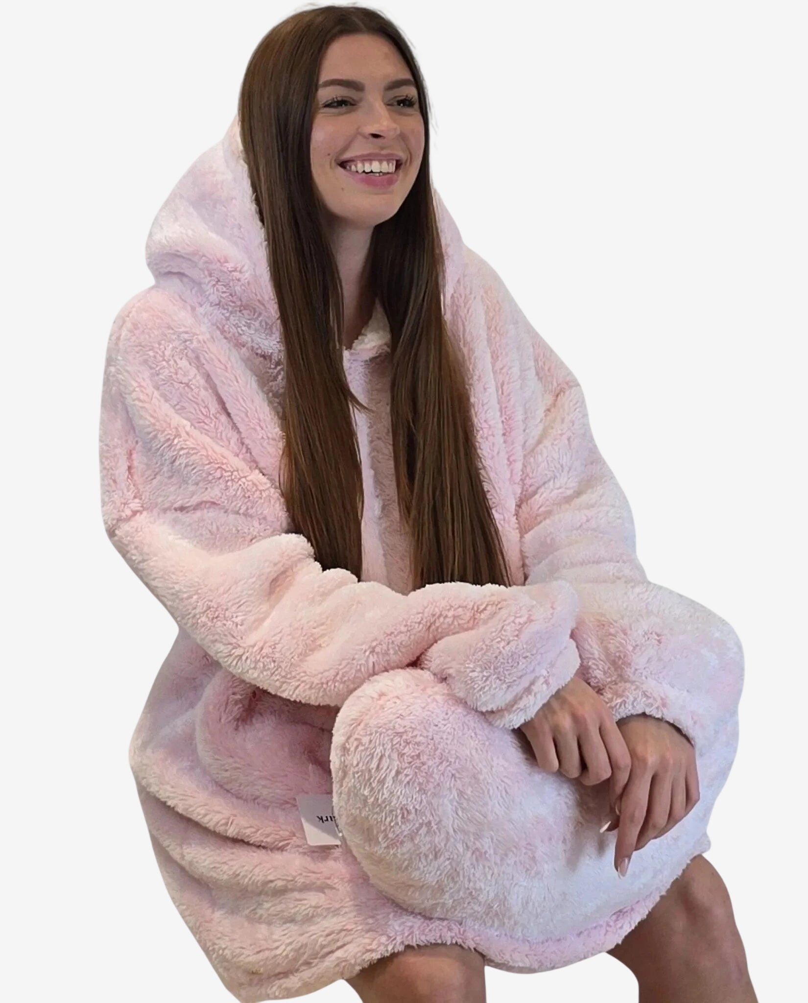 Una donna indossa un abito oversize rosa in morbido tessuto felpato con cappuccio.
