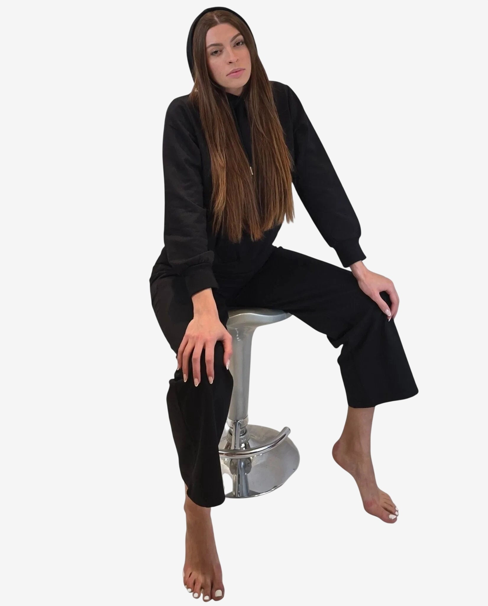 Modella indossa una felpa nera con cappuccio abbinata a pantaloni coordinati.