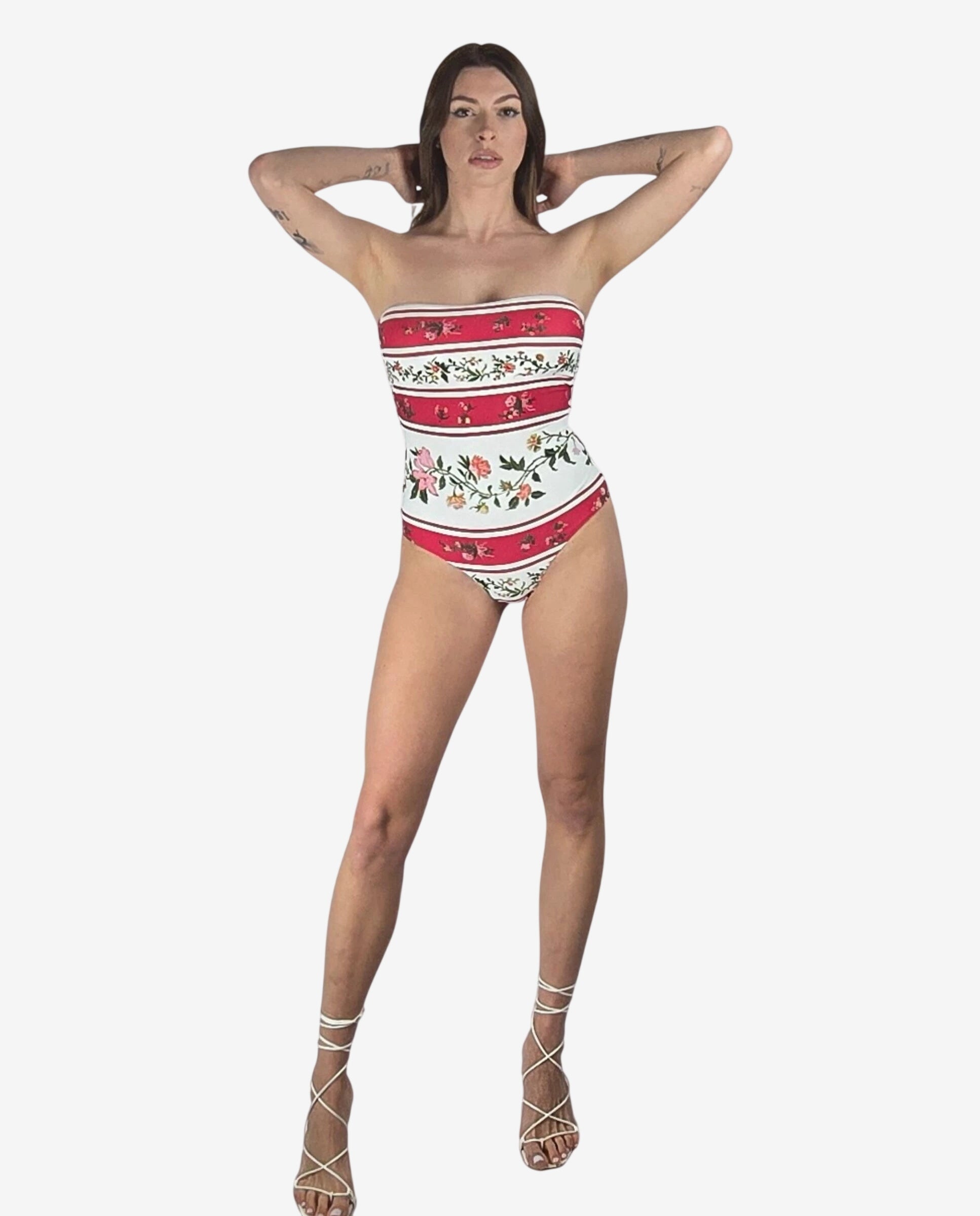 Costume intero a fascia con righe orizzontali rosse e bianche e stampa floreale.