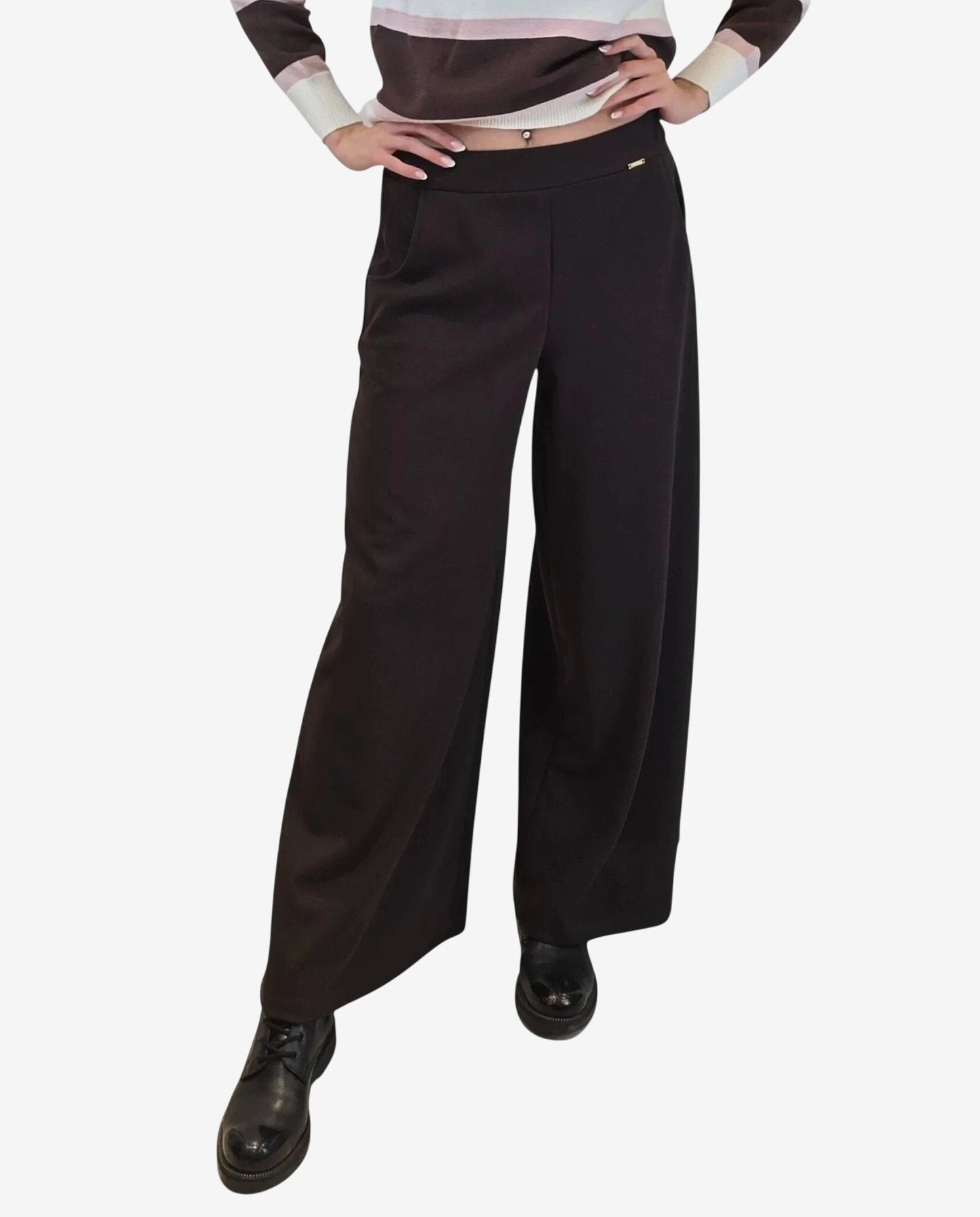 A person wears high-waisted, wide-leg moka brown trousers with a small gold-tone side detail.