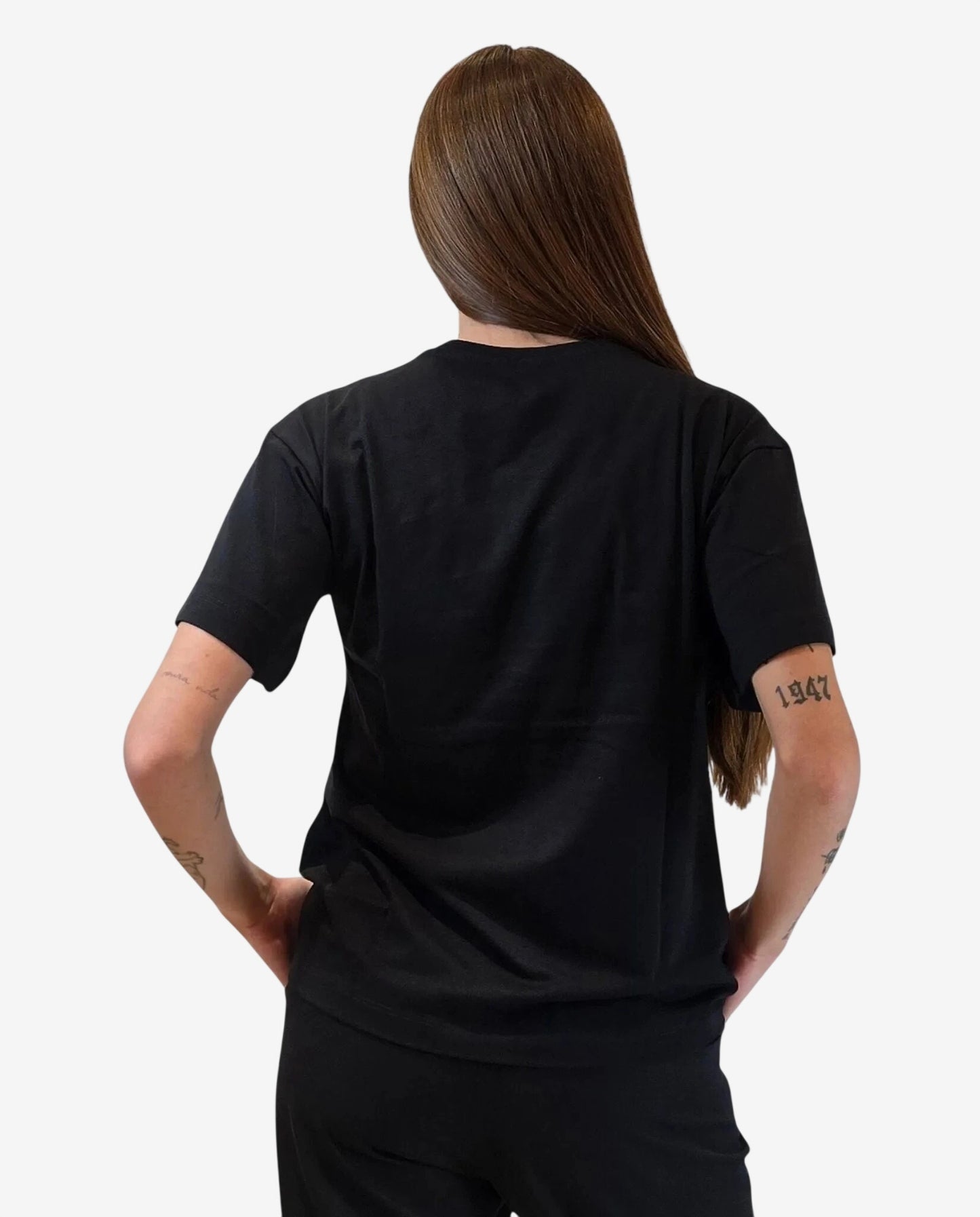 Una donna indossa una t-shirt nera a maniche corte vista di spalle.