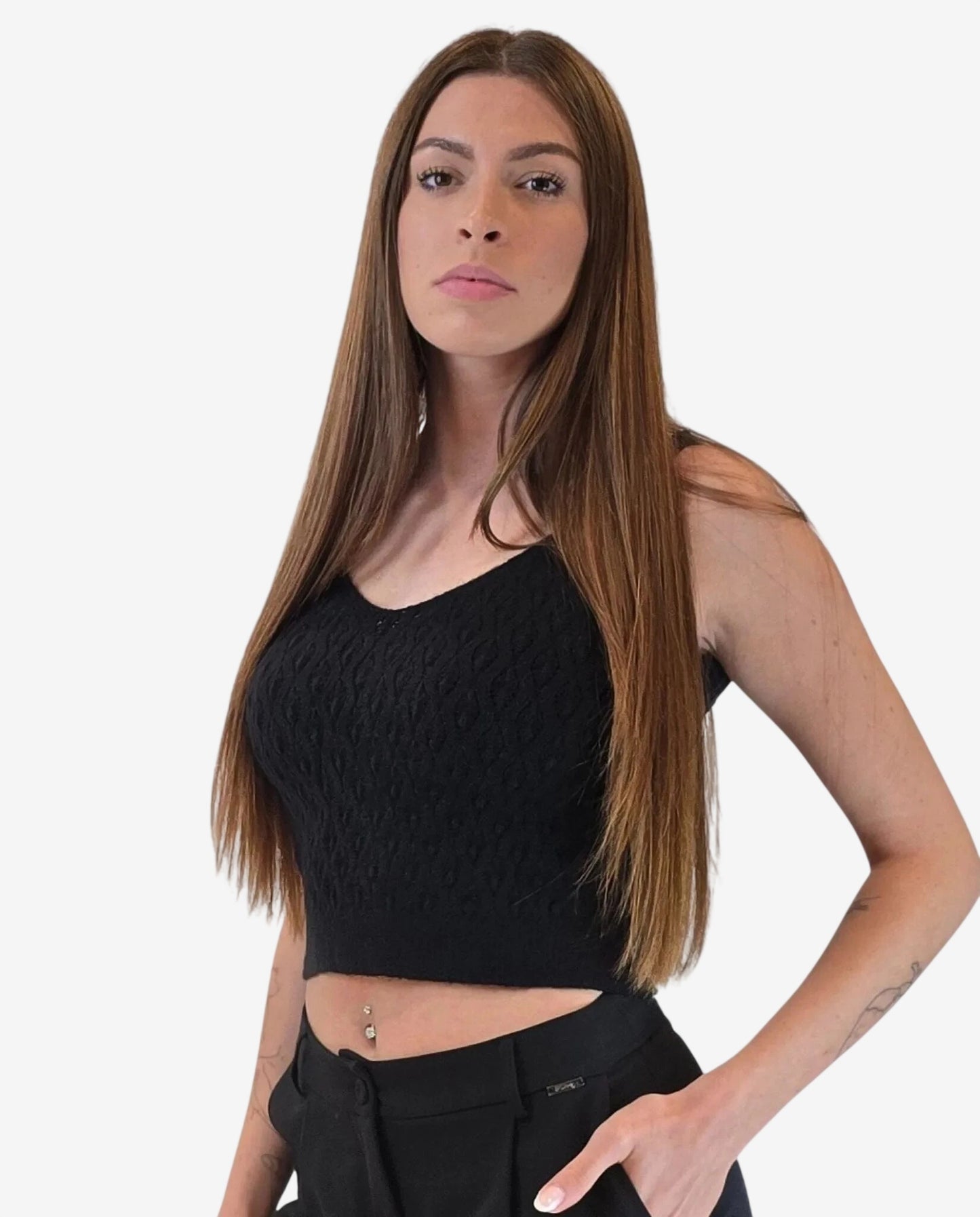 A woman wears a black sleeveless textured crop top with a V-neckline.