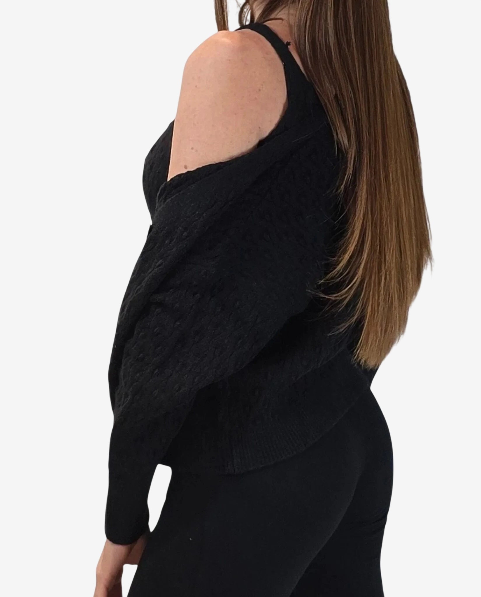 A woman wears a black textured twinset featuring a sleeveless top and a matching cardigan.