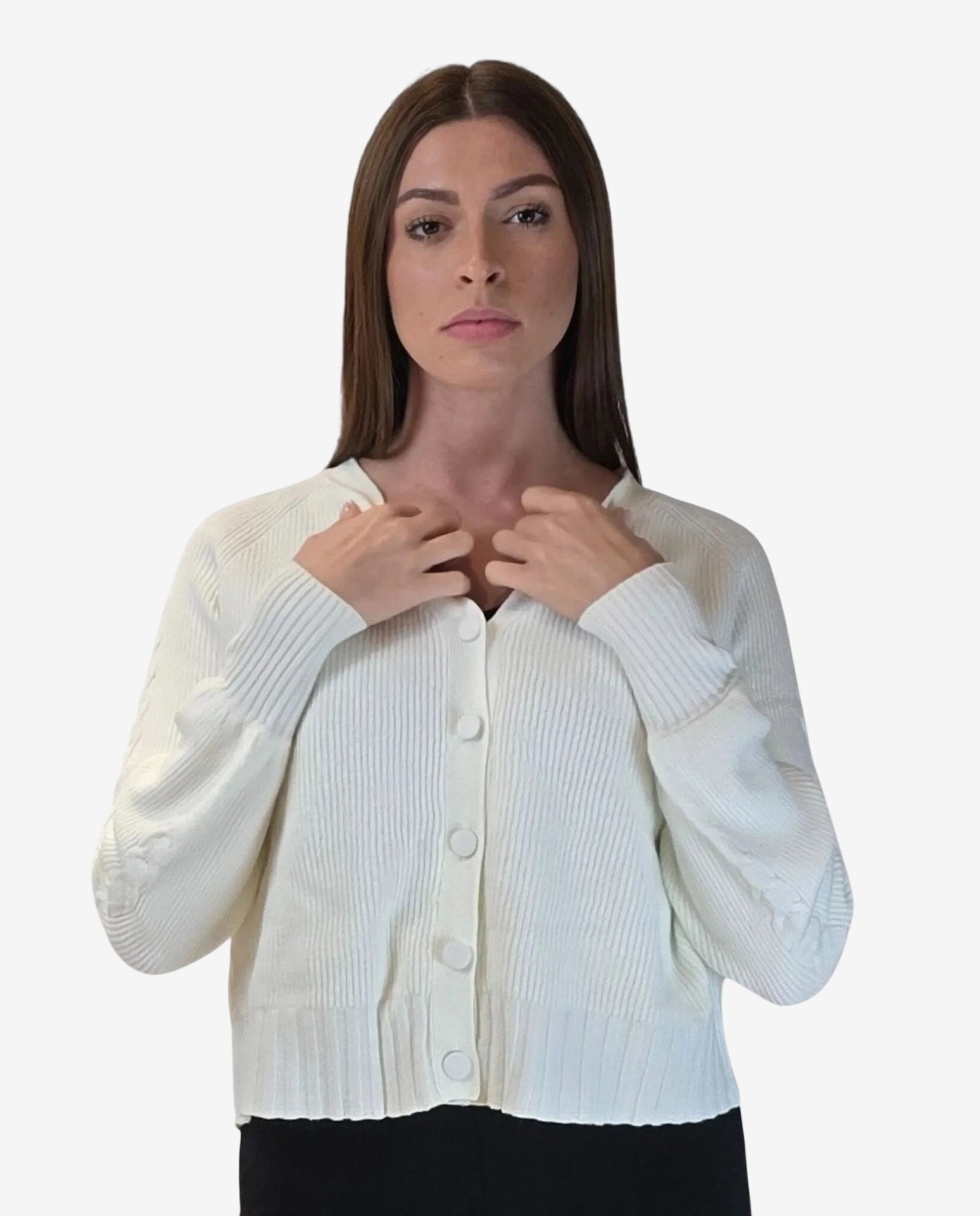 A woman wears a white, long-sleeved, ribbed knit cardigan with a button-down front.