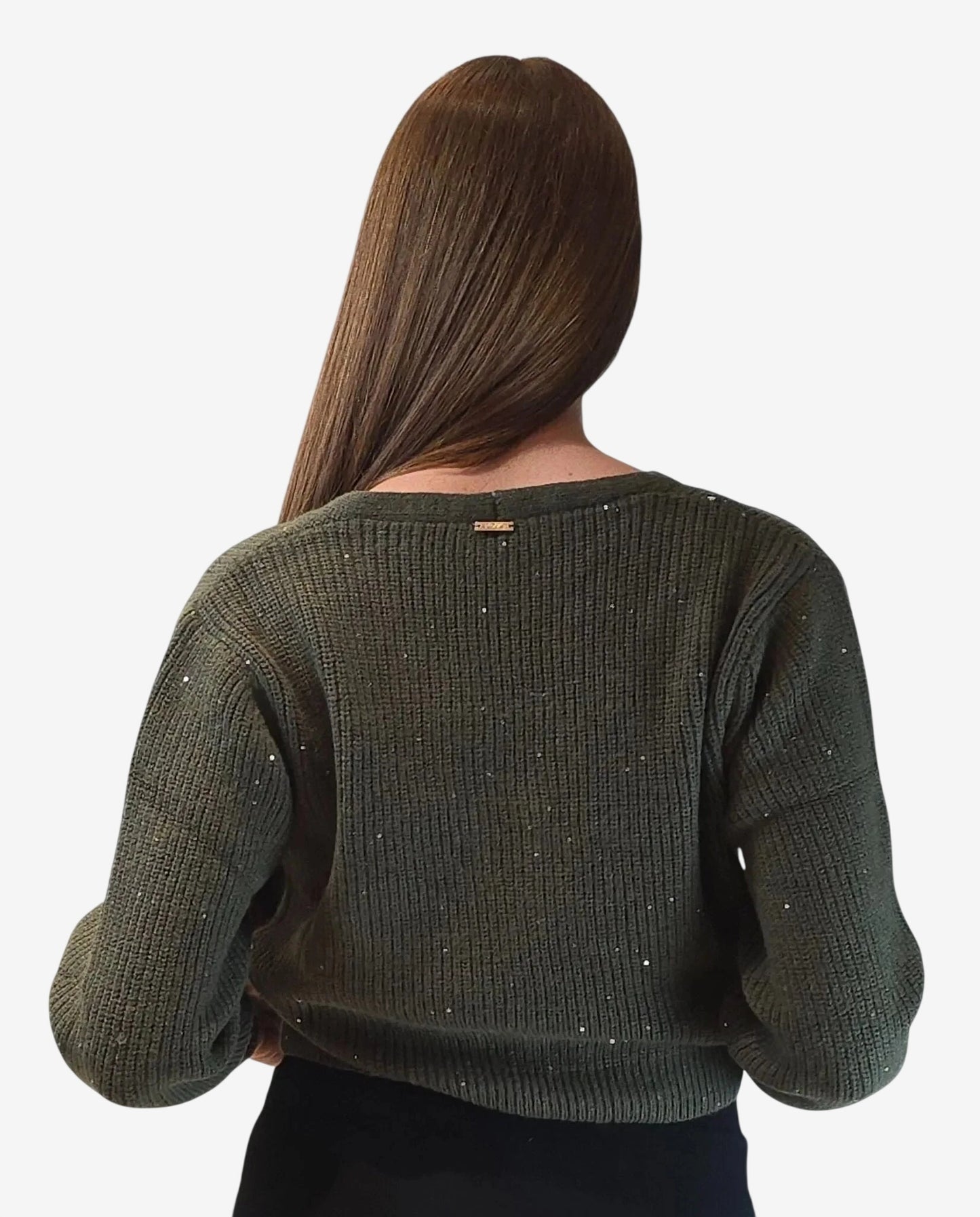 A woman seen from behind wearing a dark green ribbed sweater with small sparkling accents.