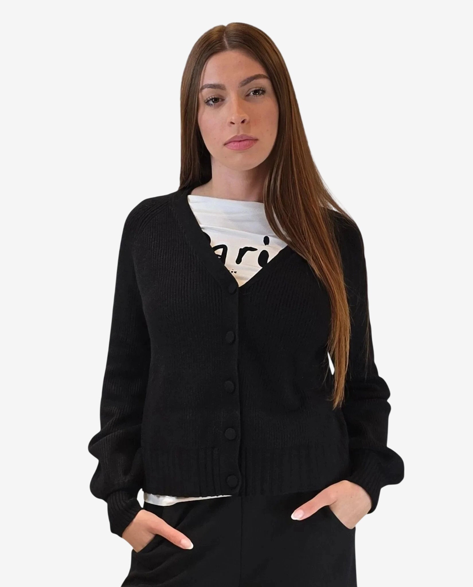 A woman wears a black button-down cardigan over a white graphic t-shirt.
