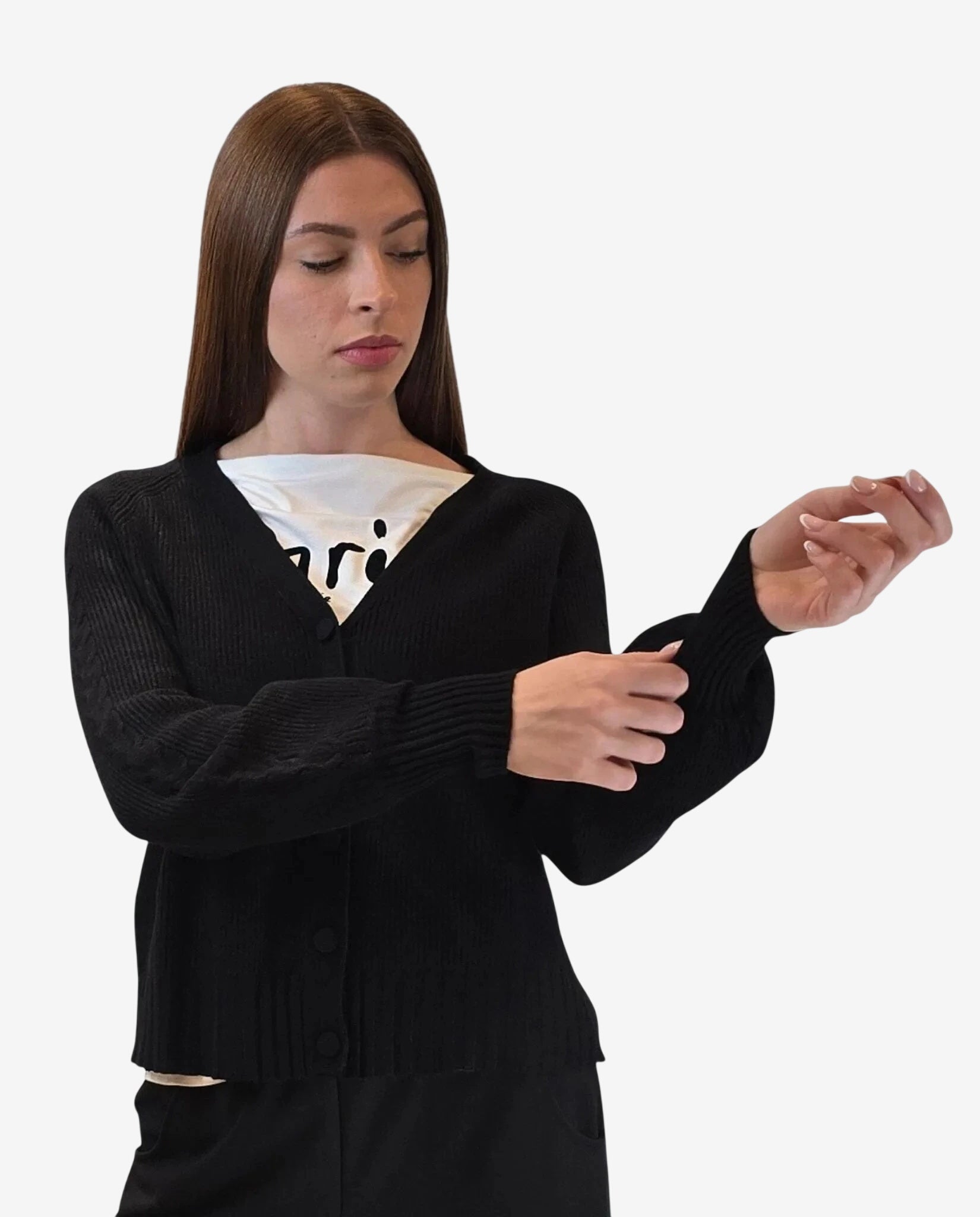 A woman wears a black button-down cardigan with ribbed cuffs over a white graphic t-shirt.