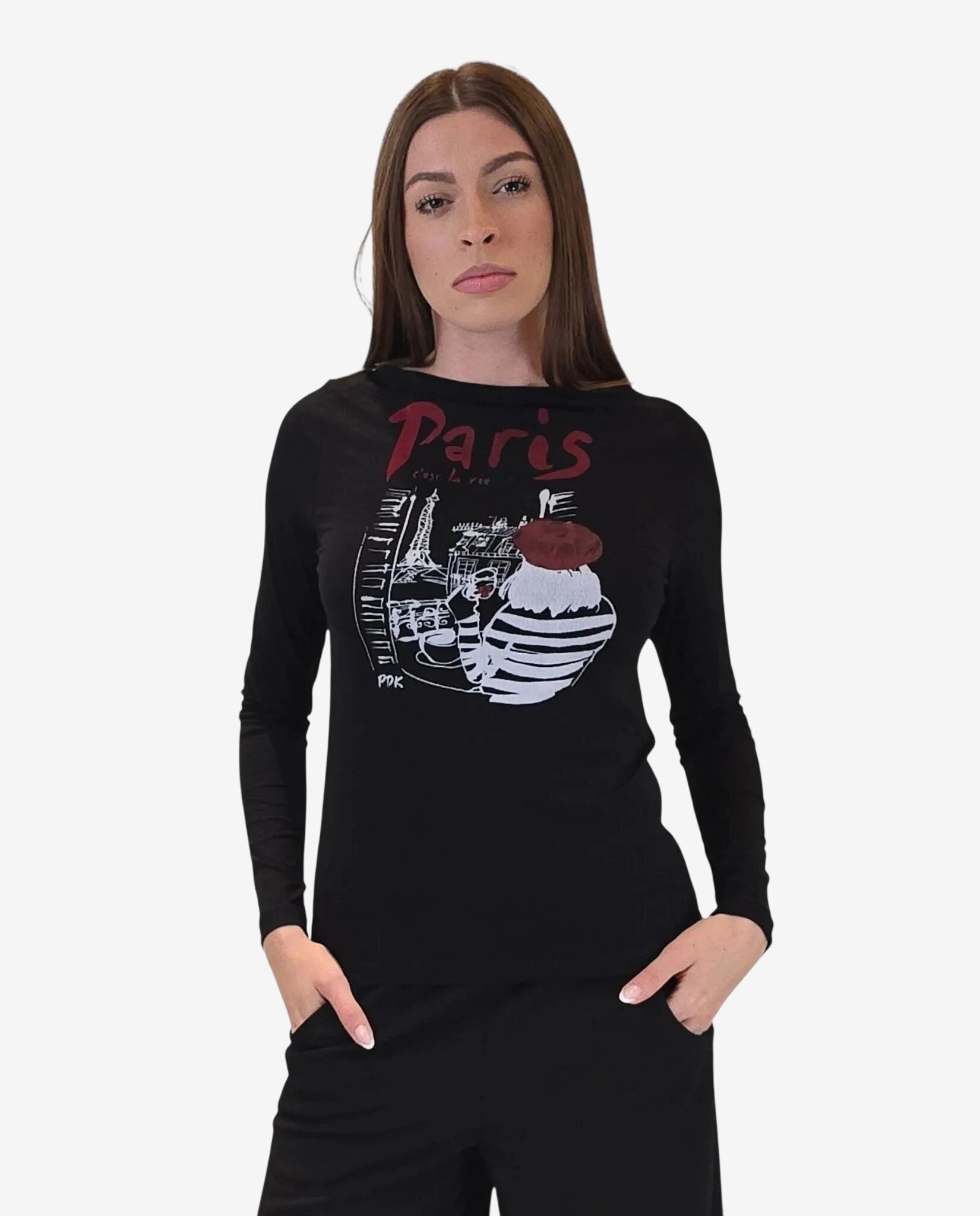 Una modella indossa una maglia nera a maniche lunghe con una stampa grafica parigina sul petto.