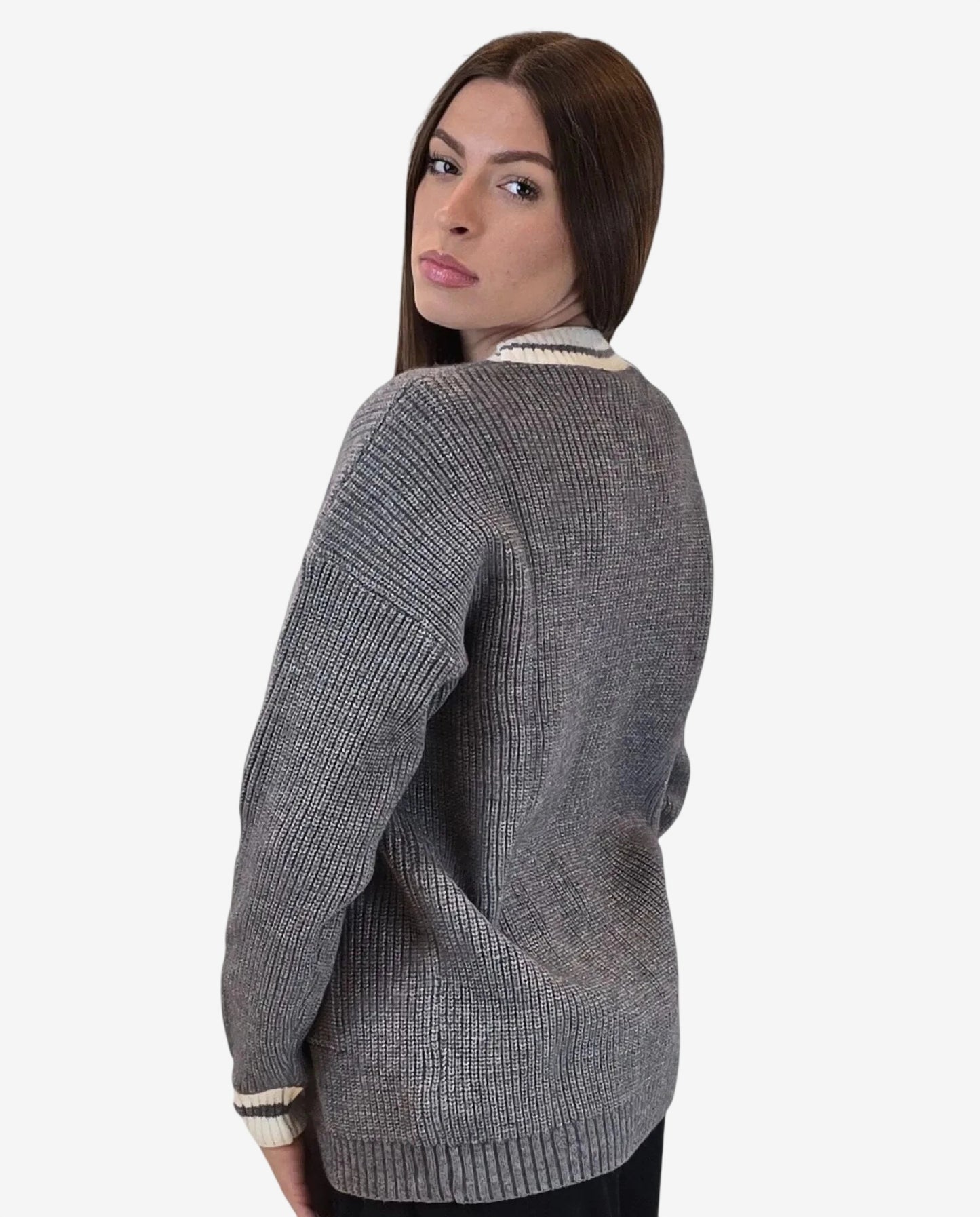 Modella indossa un cardigan grigio a coste con bordi a righe bianche e scollo a V.