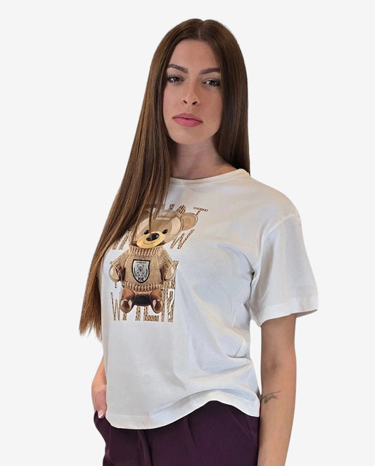 Una donna indossa una t-shirt bianca a maniche corte con una stampa di un orsacchiotto.