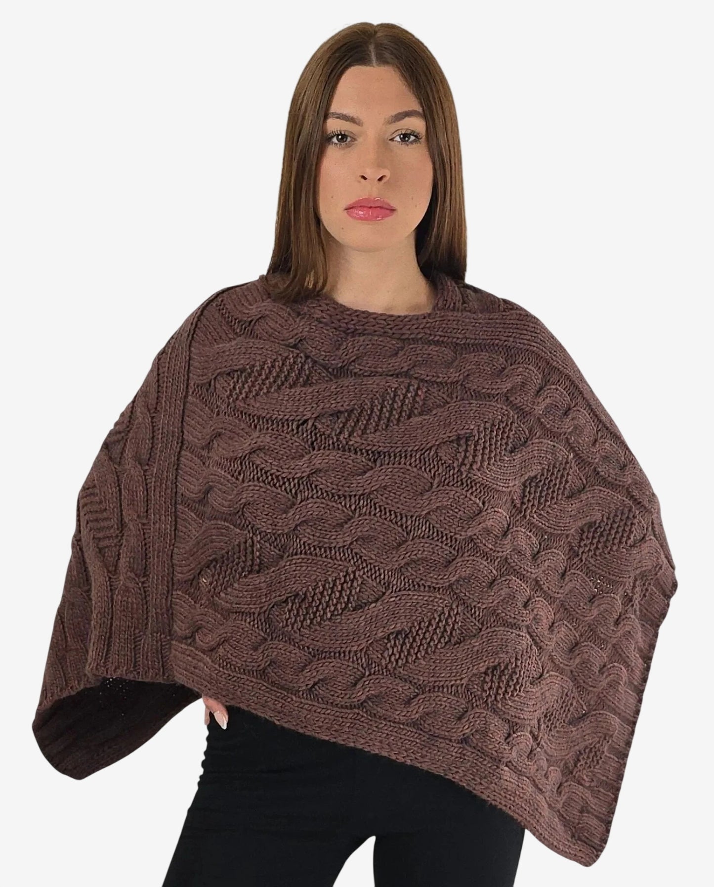 Poncho marrone in maglia con lavorazione a trecce indossato da una modella.