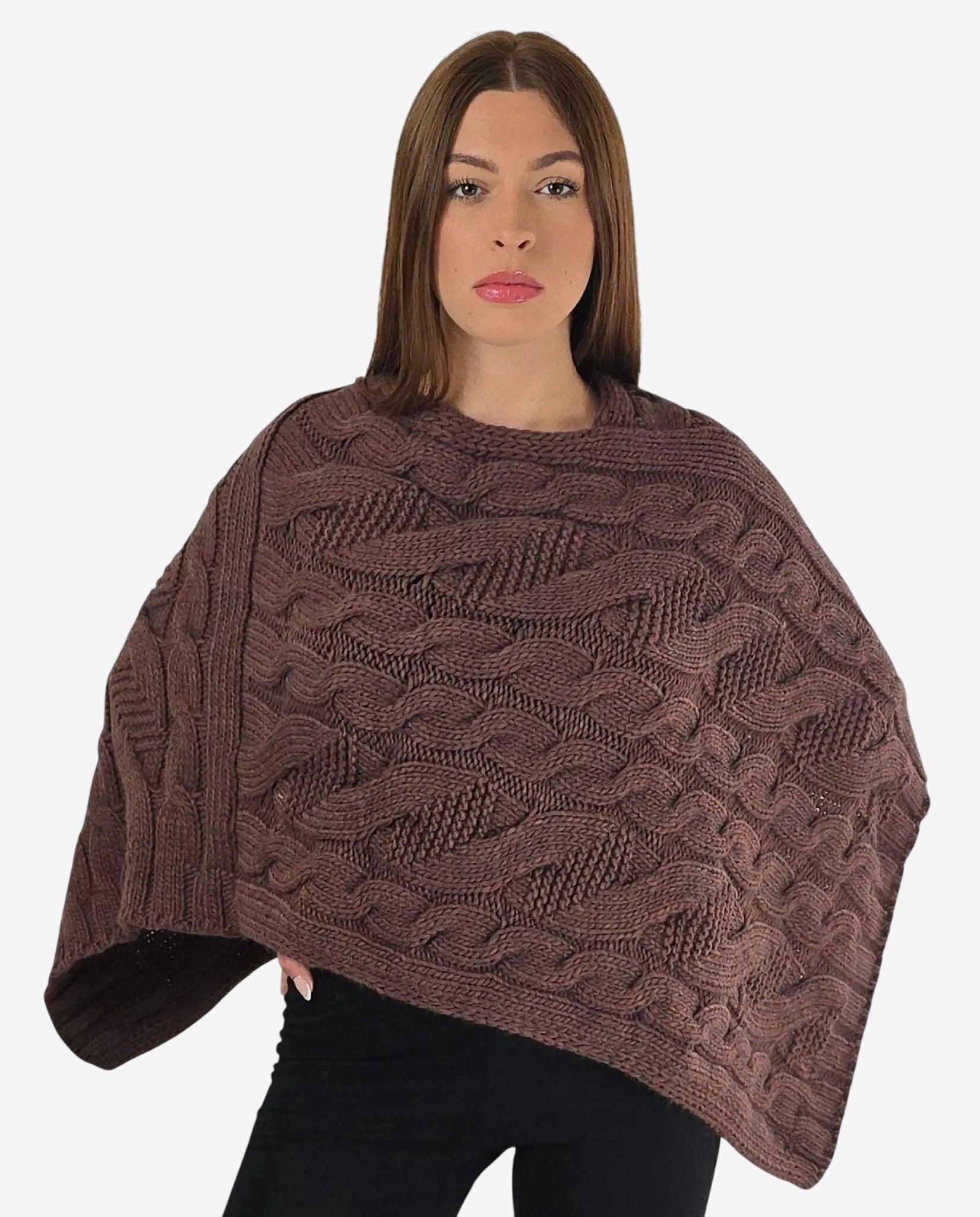 Poncho marrone in maglia con lavorazione a trecce indossato da una modella.