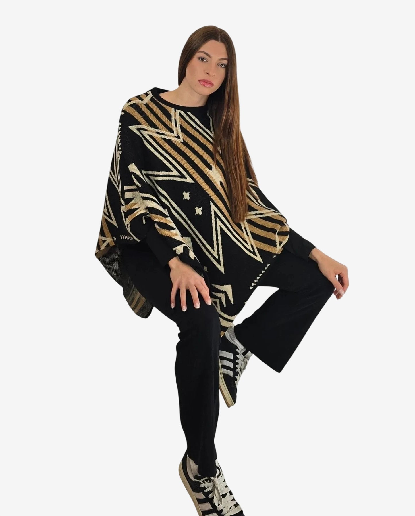 Modella indossa un poncho invernale nero in lana e alpaca con fantasia geometrica a zig zag.