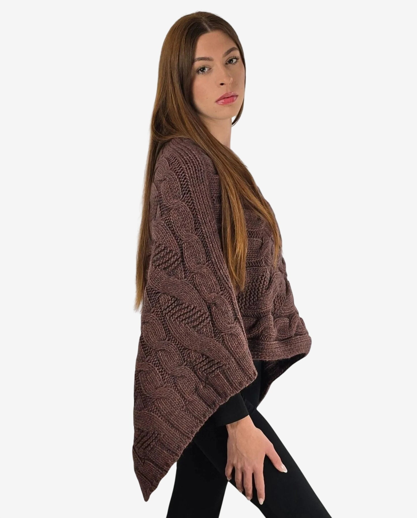 Poncho marrone in maglia con lavorazione a trecce indossato da una modella.